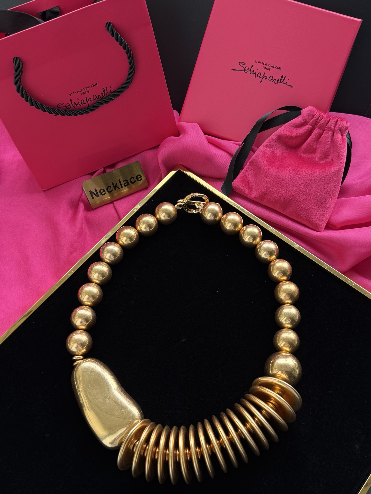 Золотистое колье с крупными бусинами и декоративным элементом Schiaparelli