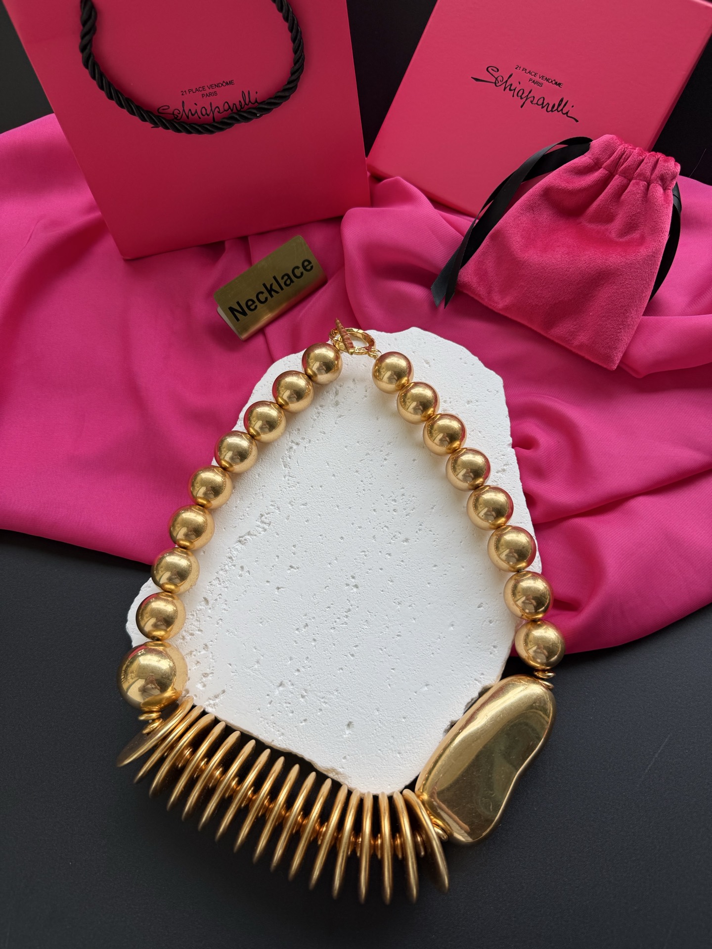 Золотистое колье с крупными бусинами и декоративным элементом Schiaparelli