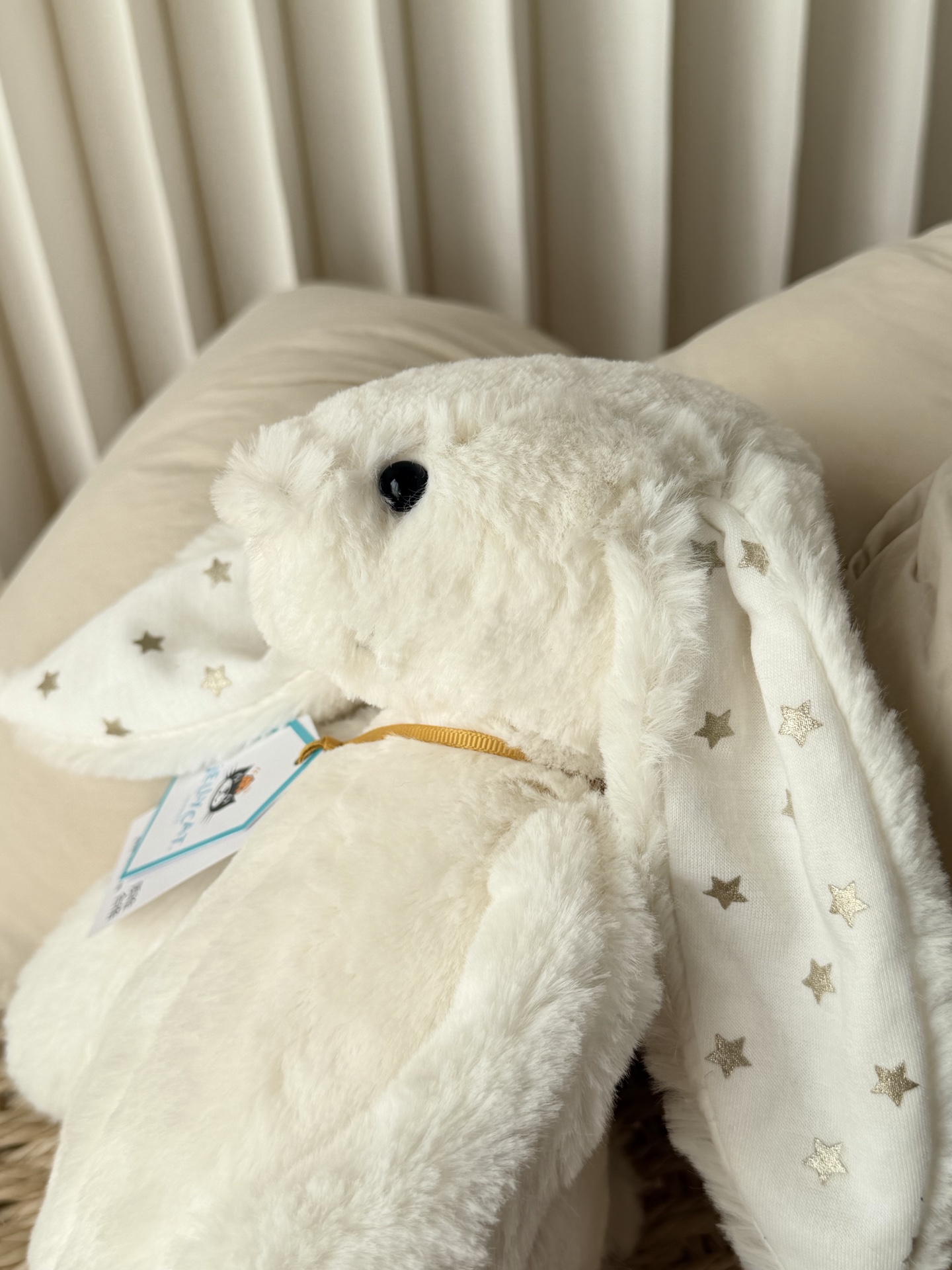 NO:811240,Round black safe hard eyes, paired with a small light pink velvet nose, round lines without edges, full of innocence. With the iconic lop ears and soft round body, it restores the soft and cute soul of the Bonnie rabbit series. On the inside of the lop ears, there is a low-key and shining silver star print. It has softness that heals everything, and also has romance hidden in the details - the milky white fluff is like winter snow, and the stars on the tips of the ears are like the thoughts you can't hide. Jellycat doll19860909圆溜溜的黑色安全硬眼睛,搭配浅粉色的小绒鼻头,线条圆润无棱角,无辜感十足.搭配标志性的垂耳与软乎乎的圆身体,还原了邦尼兔系列的软萌灵魂.垂耳内侧,印有低调又闪耀的银色星星印花.它有着治愈一切的软,也有着藏在细节里的浪漫——奶白的绒毛像冬日的雪,耳尖的星星像你藏不住的心意.,Jellycat公仔,accessory
