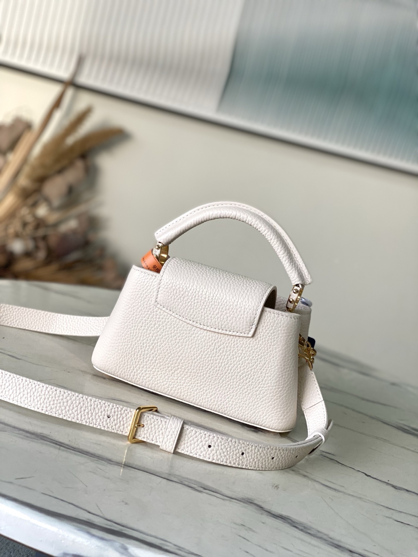 特级原厂皮 M14393 Harmony系列推出Capucines East West迷你手袋,以装饰性