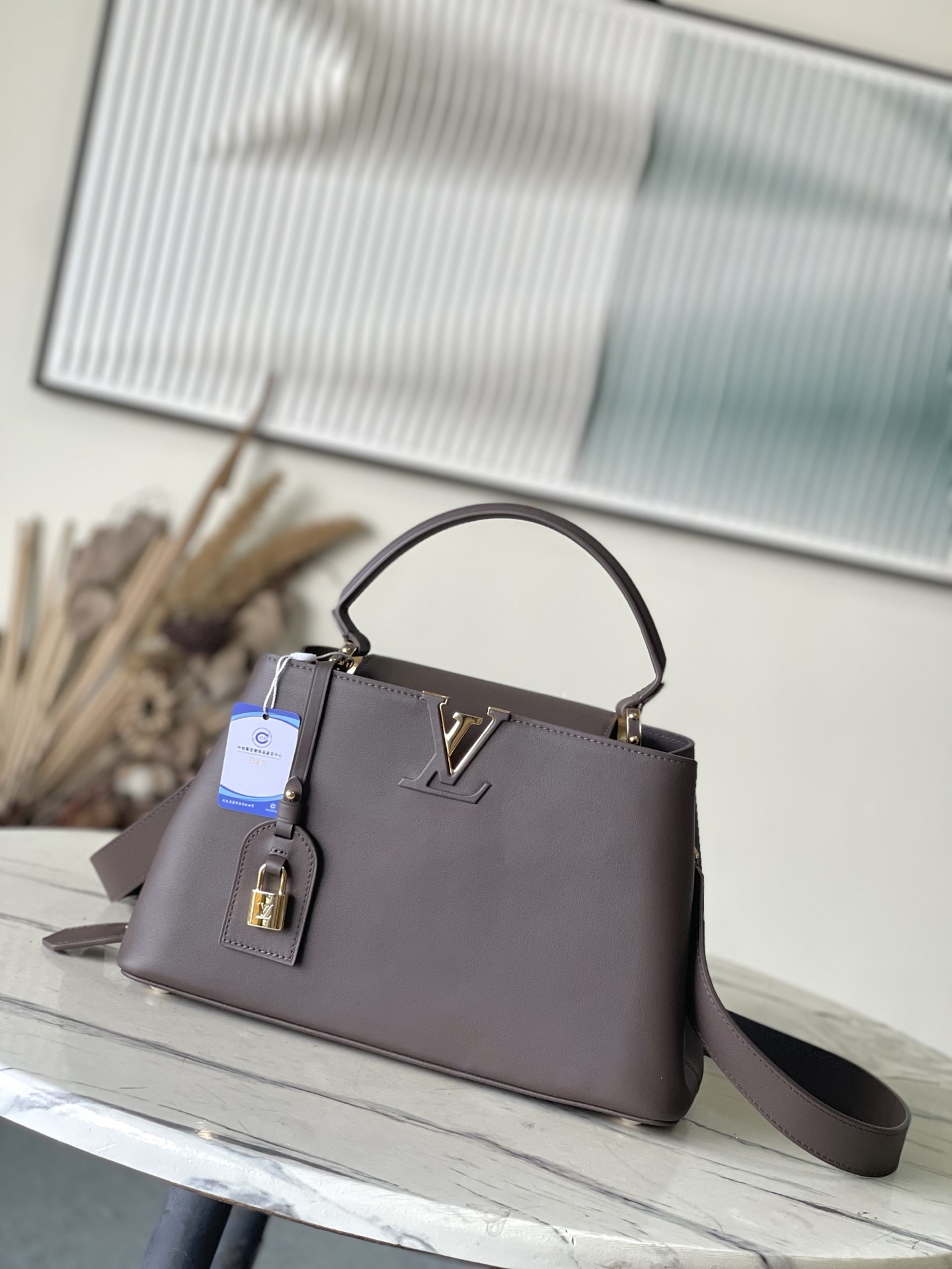 特级原厂皮 M12927 本款Capucines Souple中号手袋令亮泽牛皮革呈现褶皱效果，与耀目金