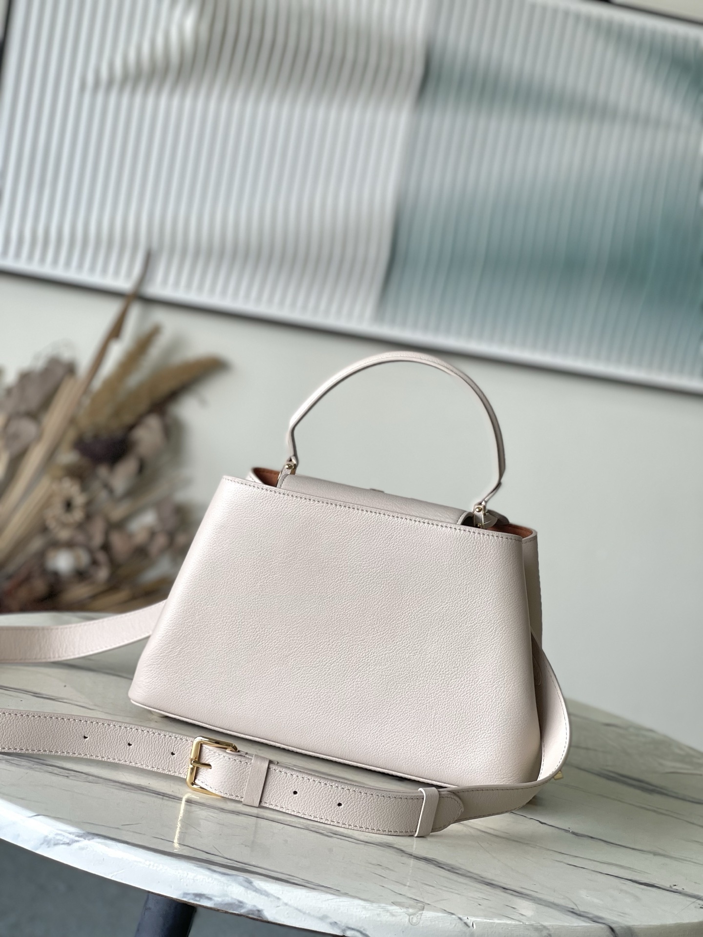 特级原厂皮 M12929 本款Capucines Souple中号手袋令亮泽牛皮革呈现褶皱效果,与耀目金