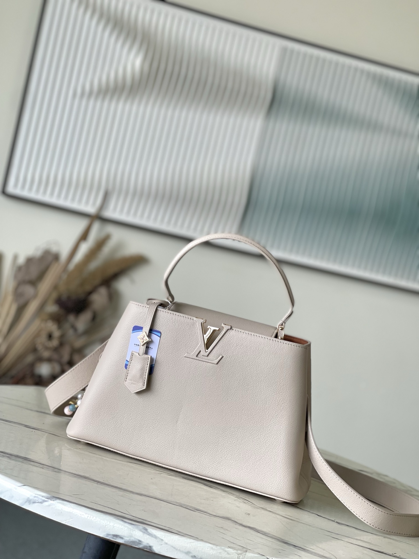 特级原厂皮 M12929 本款Capucines Souple中号手袋令亮泽牛皮革呈现褶皱效果，与耀目金