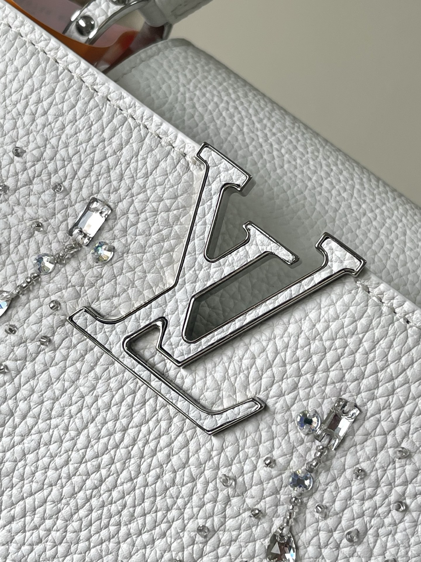 特级原厂皮 M25934 白色小号 作为“非凡系列”的一部分，这款卡普尼迷你包重新设计，采用了精致的刺绣