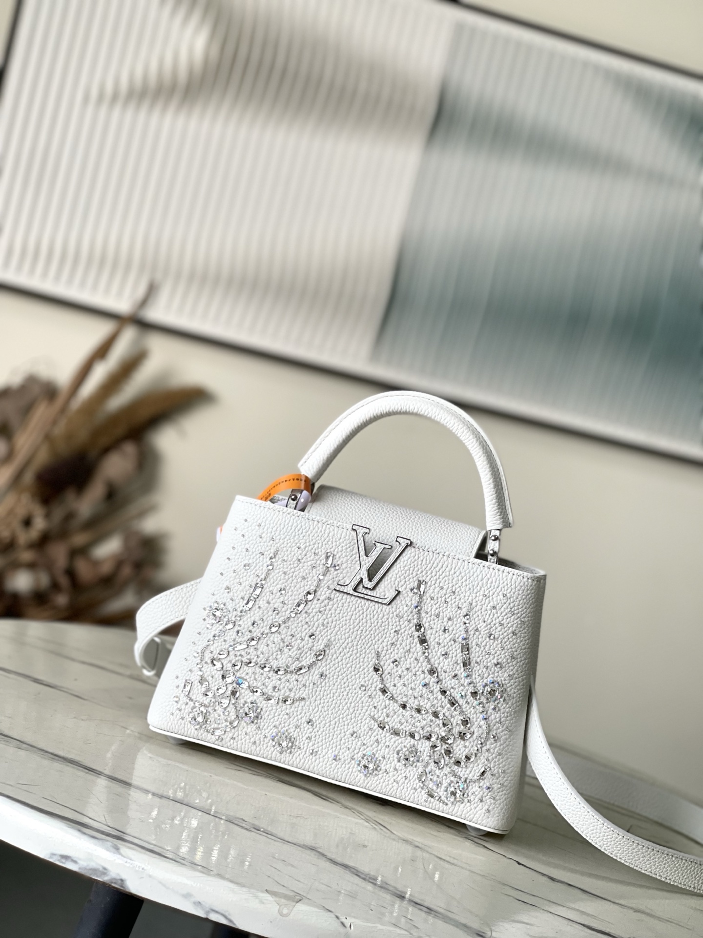 特级原厂皮 M25934 白色小号 作为“非凡系列”的一部分，这款卡普尼迷你包重新设计，采用了精致的刺绣