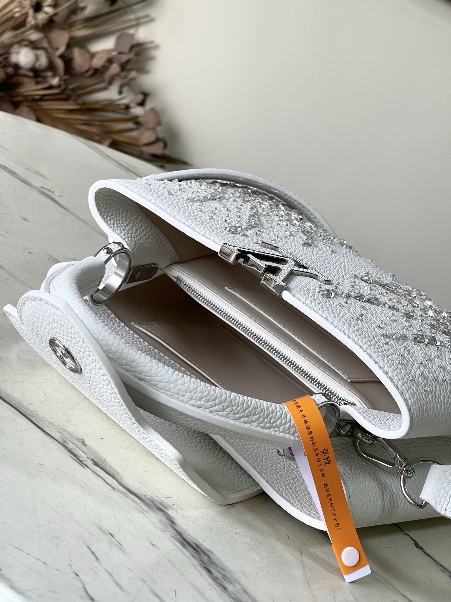 特级原厂皮 M25934 白色小号 作为“非凡系列”的一部分，这款卡普尼迷你包重新设计，采用了精致的刺绣