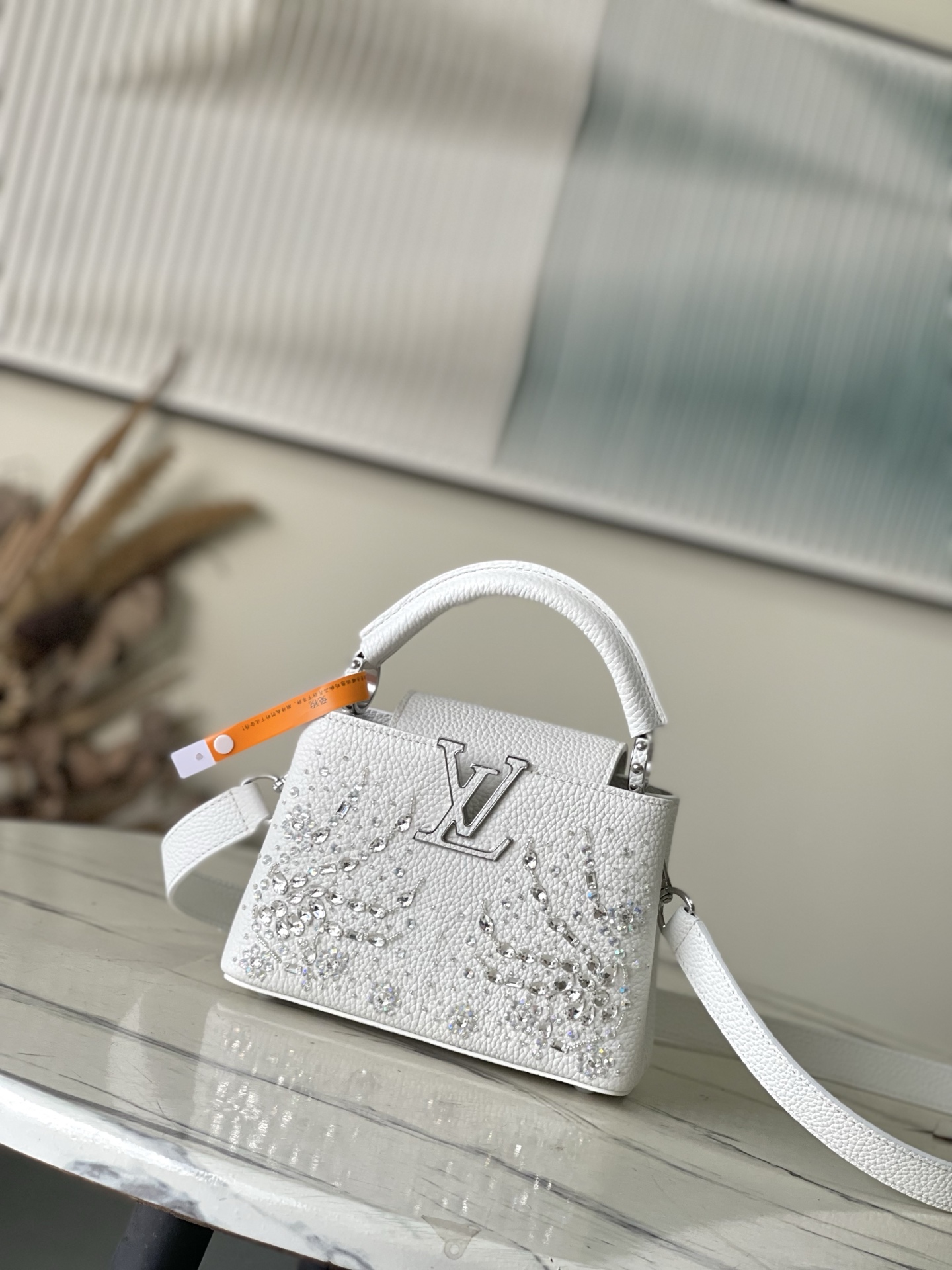 特级原厂皮 M25934 白色迷你 作为“非凡系列”的一部分，这款卡普尼迷你包重新设计，采用了精致的刺绣