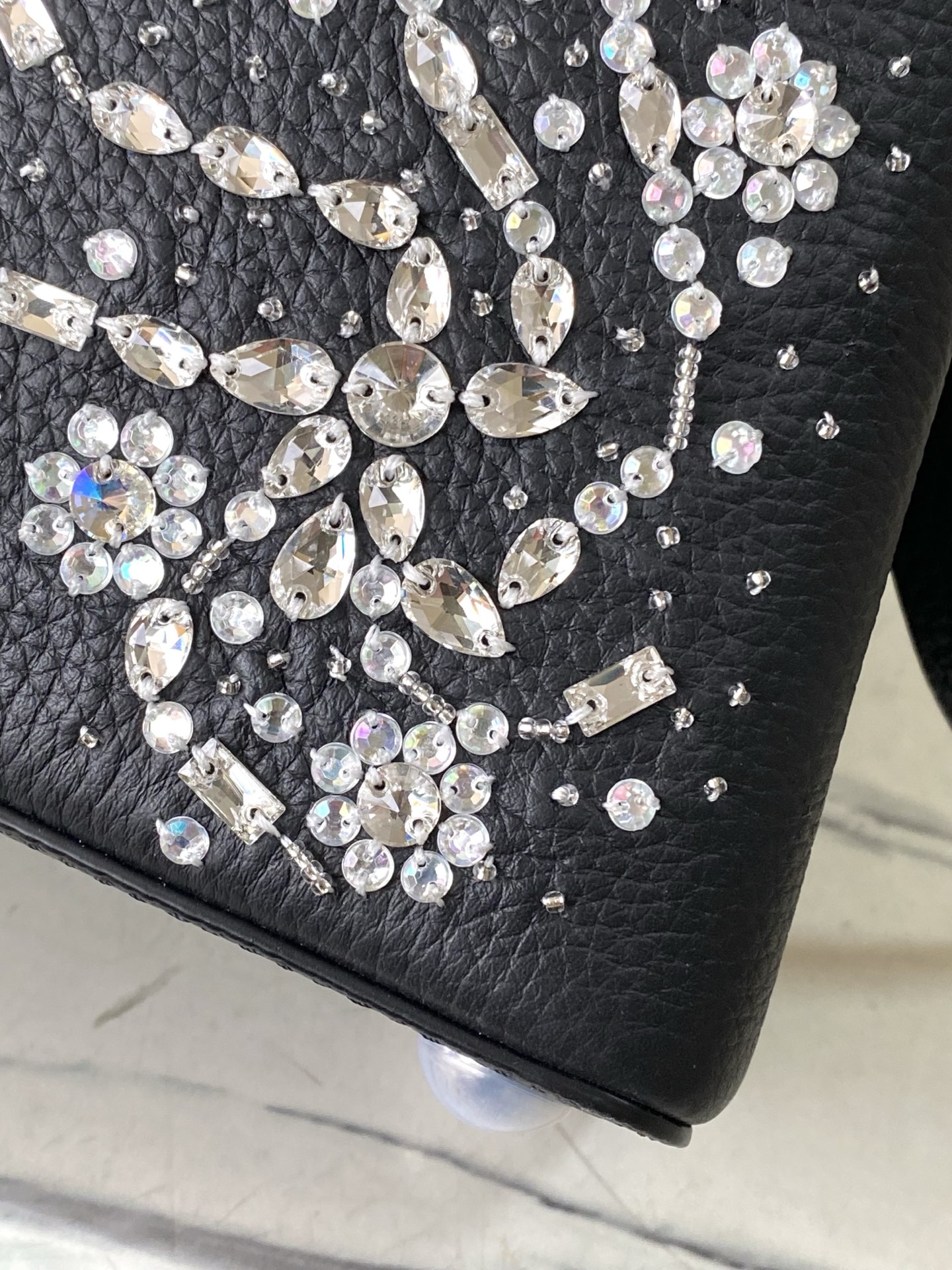 特级原厂皮 M25716 黑色小号 作为“非凡系列”的一部分，这款卡普尼迷你包重新设计，采用了精致的刺绣