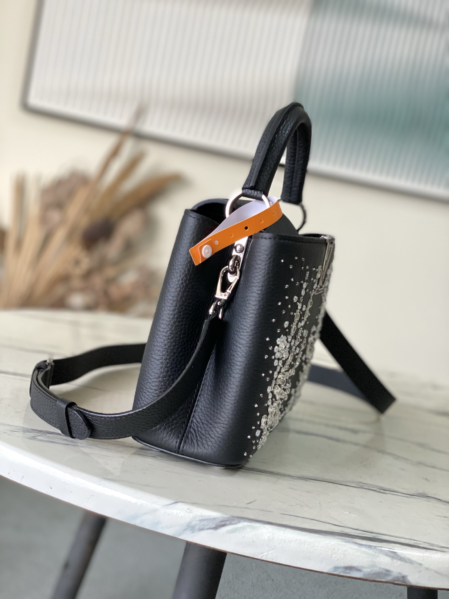 特级原厂皮 M25716 黑色小号 作为“非凡系列”的一部分，这款卡普尼迷你包重新设计，采用了精致的刺绣