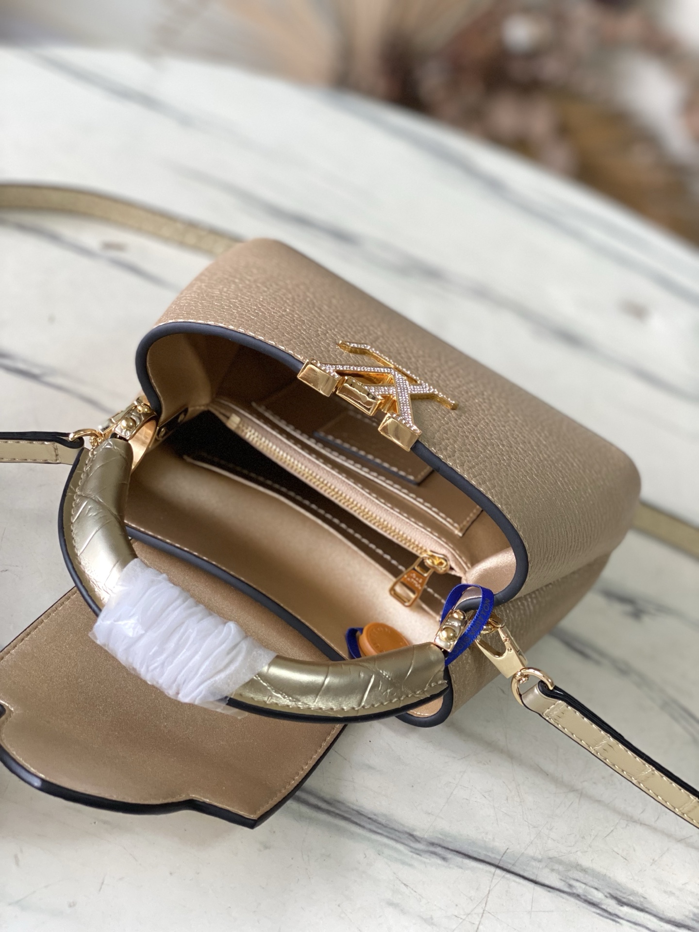 M48865金拼金鳄钻扣迷你 本季讲述全新的Capucines 故事 精致的Monogram 花卉饰带 使此款经典手袋散