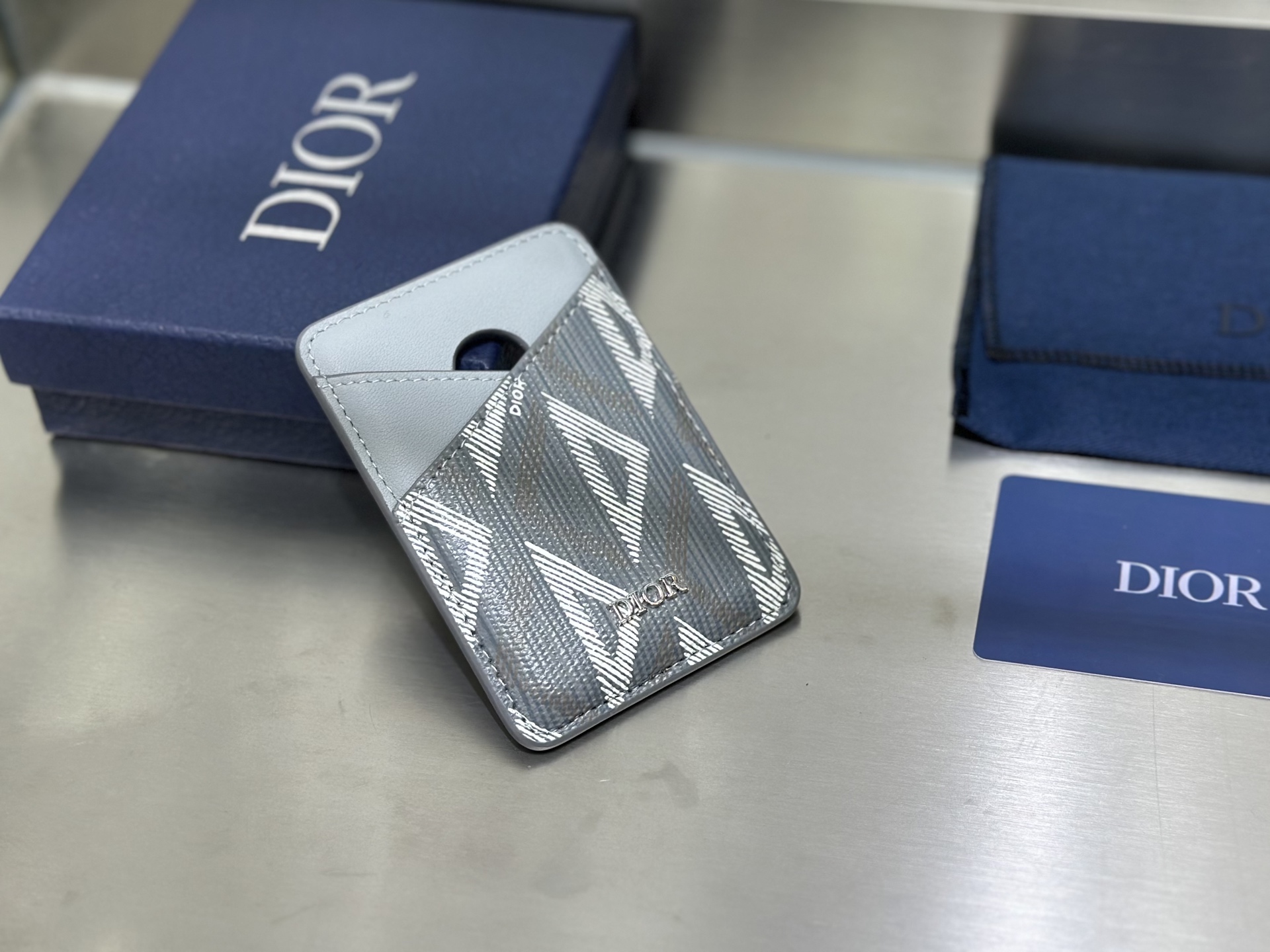 这款马鞍磁性卡夹是一款高雅的配饰，彰显 Dior 精湛的皮革细工镶嵌工艺。采用Oblique 印花面料和