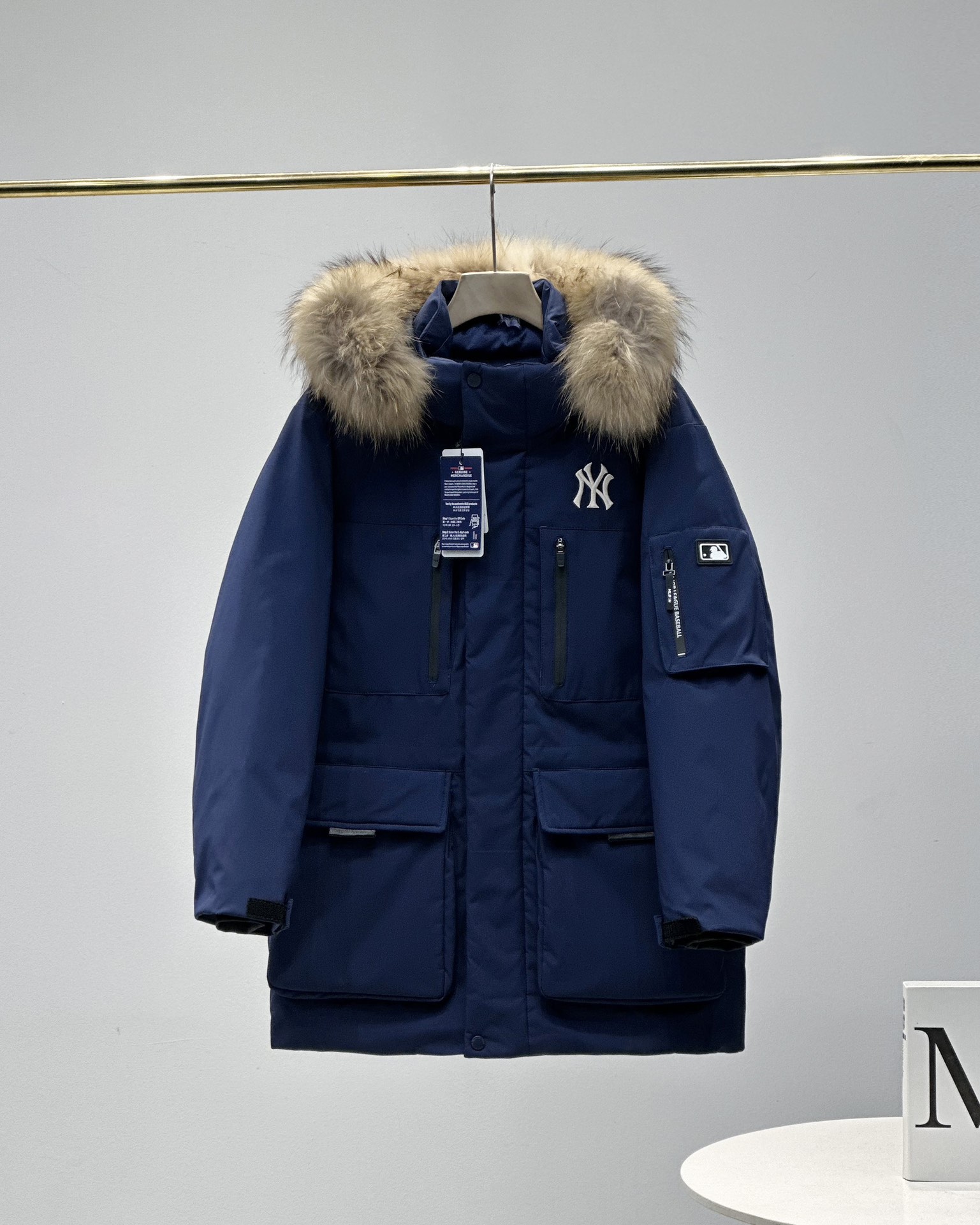 顶级💰450 代购级💰550 正品级💰680  
五色齐发  奢华真毛领 区别市场任何毛领 ）
MLB/男女24冬季新款张凌赫同款鹅绒毛领加厚羽绒服户外中长款外套💗（原单货）
区别普通版本！🉑对比毛领➕细节➕三标水洗👍
明星同款，机能风潮，时尚有型。
张凌赫今年代言的海报上身款！出席店庆活动时也是身着这款！可谓今年品牌的主力款式！
工装风多口袋设计，面料不是薄薄一层，是手感厚实的定制三防面料，防风防泼水。袖臂和前胸拉链都是采用防水拉链。户外穿着更保暖！
柔软真皮草毛领，大大的一整根貉子毛领，不仅挡风保暖，更加的显奢华质感，一眼贵价羽绒服！
胸口重工贴布&ldquo;刺绣&rdquo;MLB标志性的NY logo，袖臂插袋饰有经典的硅胶标，品牌辨识度极强。
中长款，长度盖住臀部，针织双层袖口，抵御寒风，东北极寒都是妥妥的能扛住！！
填充国标600蓬90白鹅绒！打开后挂起来拍打一下，静待毛领和衣服舒展蓬起来！
帽子和下摆自带可调节抽绳和锁扣，包裹暖意，随心自如！
大厂工艺精细，走线工整！ 细节处理完美😘
四个色，黑色 白色是永远的经典，怎么穿都好看。浅藏青颜色质感非常高级。浅驼色特别色 显白 穿着好看🈶气质👍

颜色。黑色    奶白色    浅青色     浅驼色   灰色
尺码XＳ&mdash;XXL
尺码   衣长    肩宽   胸围     袖长    推荐体重
XS       76       50     120       60    80-100
S        78       51     122       61      100-120
Ｍ       80       52    126       62      120-140
L        82       53     130      63.5    140-160
XL      84       54     134      64.5    160-180
XXL    86       55     138      65.5    180-200

​