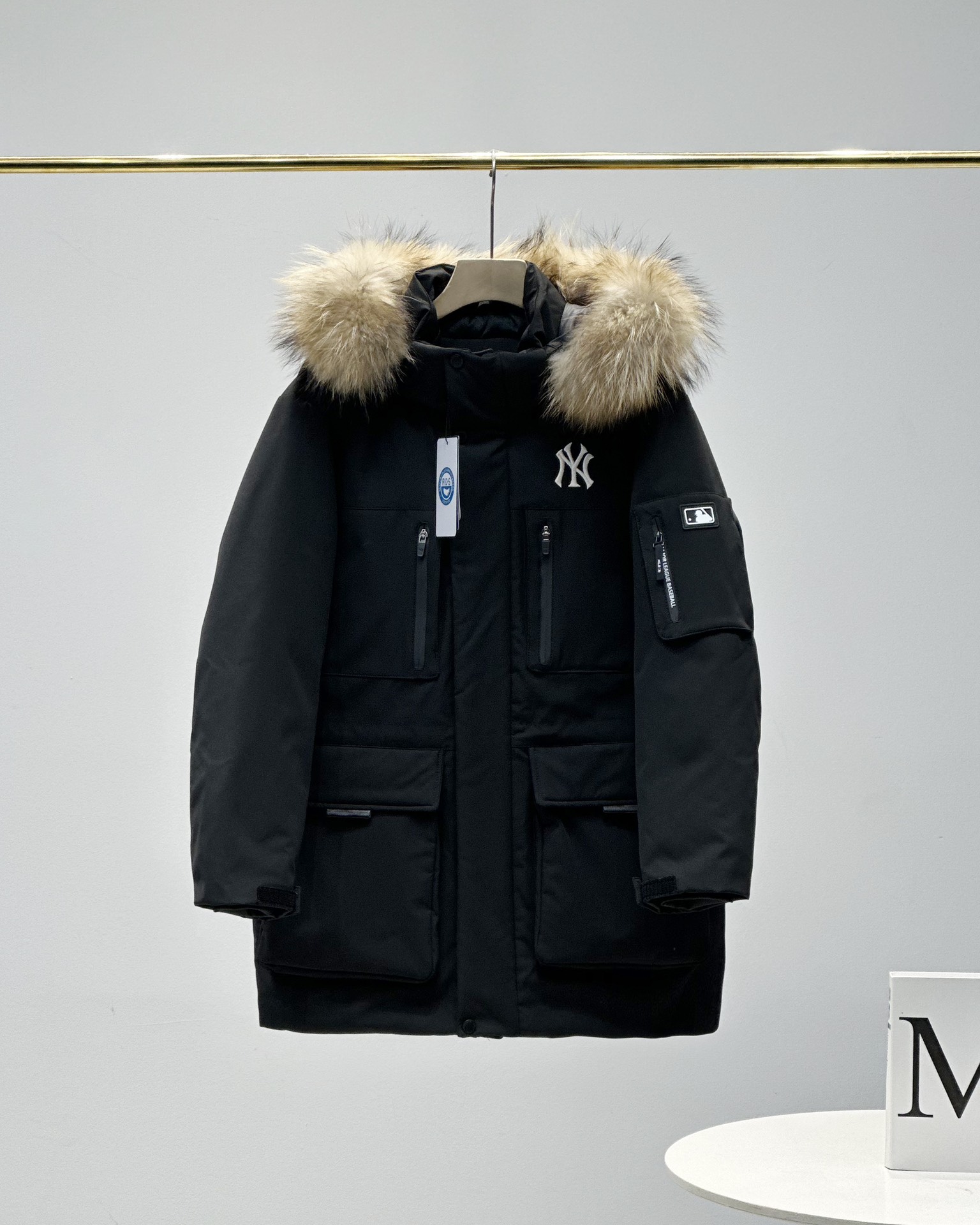 顶级💰450 代购级💰550 正品级💰680  
五色齐发  奢华真毛领 区别市场任何毛领 ）
MLB/男女24冬季新款张凌赫同款鹅绒毛领加厚羽绒服户外中长款外套💗（原单货）
区别普通版本！🉑对比毛领➕细节➕三标水洗👍
明星同款，机能风潮，时尚有型。
张凌赫今年代言的海报上身款！出席店庆活动时也是身着这款！可谓今年品牌的主力款式！
工装风多口袋设计，面料不是薄薄一层，是手感厚实的定制三防面料，防风防泼水。袖臂和前胸拉链都是采用防水拉链。户外穿着更保暖！
柔软真皮草毛领，大大的一整根貉子毛领，不仅挡风保暖，更加的显奢华质感，一眼贵价羽绒服！
胸口重工贴布&ldquo;刺绣&rdquo;MLB标志性的NY logo，袖臂插袋饰有经典的硅胶标，品牌辨识度极强。
中长款，长度盖住臀部，针织双层袖口，抵御寒风，东北极寒都是妥妥的能扛住！！
填充国标600蓬90白鹅绒！打开后挂起来拍打一下，静待毛领和衣服舒展蓬起来！
帽子和下摆自带可调节抽绳和锁扣，包裹暖意，随心自如！
大厂工艺精细，走线工整！ 细节处理完美😘
四个色，黑色 白色是永远的经典，怎么穿都好看。浅藏青颜色质感非常高级。浅驼色特别色 显白 穿着好看🈶气质👍

颜色。黑色    奶白色    浅青色     浅驼色   灰色
尺码XＳ&mdash;XXL
尺码   衣长    肩宽   胸围     袖长    推荐体重
XS       76       50     120       60    80-100
S        78       51     122       61      100-120
Ｍ       80       52    126       62      120-140
L        82       53     130      63.5    140-160
XL      84       54     134      64.5    160-180
XXL    86       55     138      65.5    180-200

​