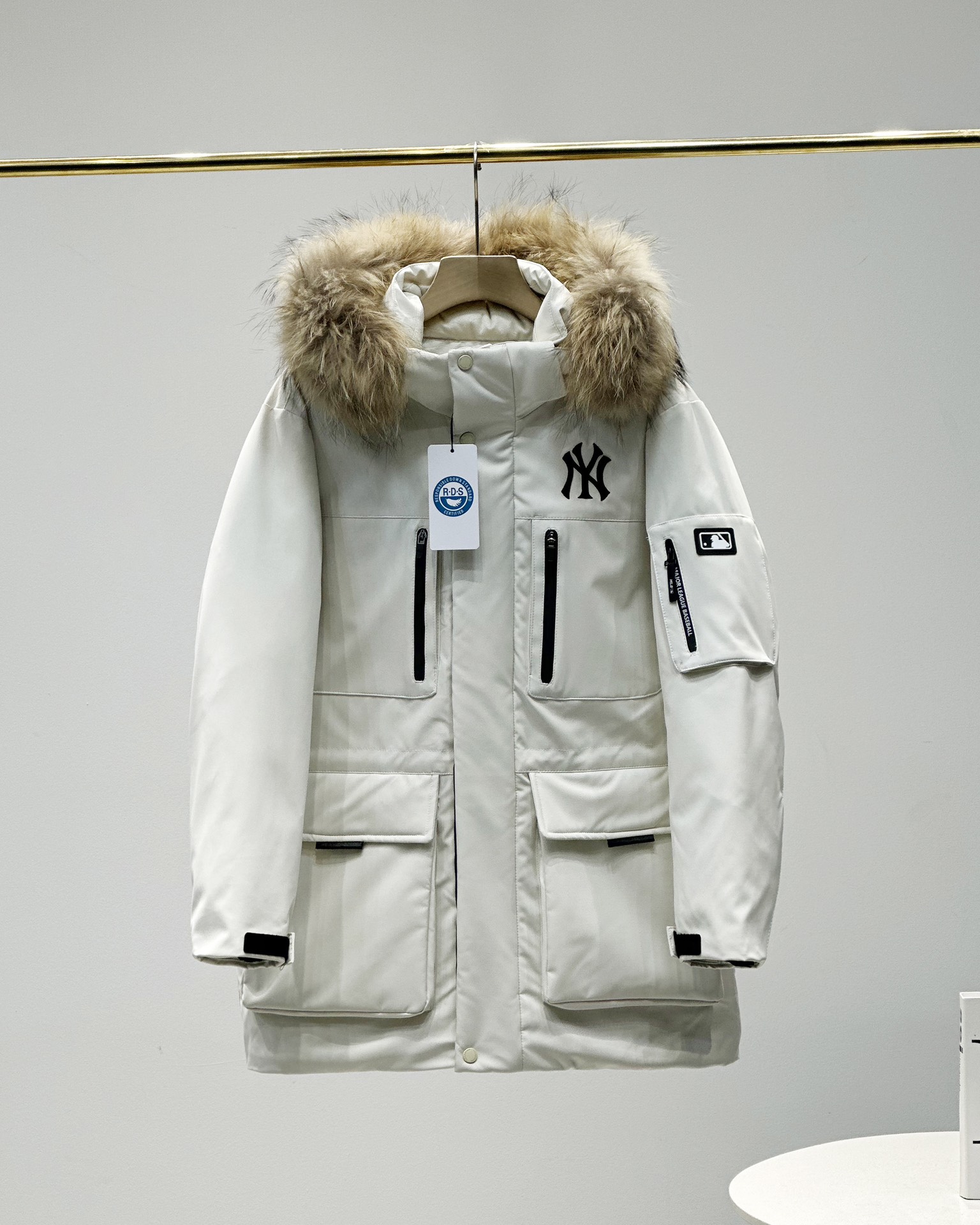 顶级💰450 代购级💰550 正品级💰680  
五色齐发  奢华真毛领 区别市场任何毛领 ）
MLB/男女24冬季新款张凌赫同款鹅绒毛领加厚羽绒服户外中长款外套💗（原单货）
区别普通版本！🉑对比毛领➕细节➕三标水洗👍
明星同款，机能风潮，时尚有型。
张凌赫今年代言的海报上身款！出席店庆活动时也是身着这款！可谓今年品牌的主力款式！
工装风多口袋设计，面料不是薄薄一层，是手感厚实的定制三防面料，防风防泼水。袖臂和前胸拉链都是采用防水拉链。户外穿着更保暖！
柔软真皮草毛领，大大的一整根貉子毛领，不仅挡风保暖，更加的显奢华质感，一眼贵价羽绒服！
胸口重工贴布&ldquo;刺绣&rdquo;MLB标志性的NY logo，袖臂插袋饰有经典的硅胶标，品牌辨识度极强。
中长款，长度盖住臀部，针织双层袖口，抵御寒风，东北极寒都是妥妥的能扛住！！
填充国标600蓬90白鹅绒！打开后挂起来拍打一下，静待毛领和衣服舒展蓬起来！
帽子和下摆自带可调节抽绳和锁扣，包裹暖意，随心自如！
大厂工艺精细，走线工整！ 细节处理完美😘
四个色，黑色 白色是永远的经典，怎么穿都好看。浅藏青颜色质感非常高级。浅驼色特别色 显白 穿着好看🈶气质👍

颜色。黑色    奶白色    浅青色     浅驼色   灰色
尺码XＳ&mdash;XXL
尺码   衣长    肩宽   胸围     袖长    推荐体重
XS       76       50     120       60    80-100
S        78       51     122       61      100-120
Ｍ       80       52    126       62      120-140
L        82       53     130      63.5    140-160
XL      84       54     134      64.5    160-180
XXL    86       55     138      65.5    180-200

​