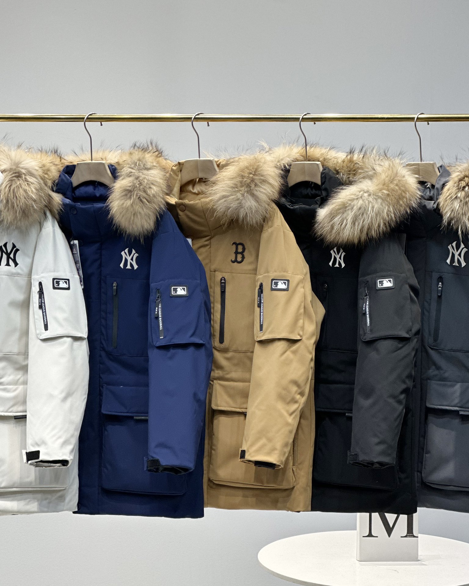 顶级💰450 代购级💰550 正品级💰680  
五色齐发  奢华真毛领 区别市场任何毛领 ）
MLB/男女24冬季新款张凌赫同款鹅绒毛领加厚羽绒服户外中长款外套💗（原单货）
区别普通版本！🉑对比毛领➕细节➕三标水洗👍
明星同款，机能风潮，时尚有型。
张凌赫今年代言的海报上身款！出席店庆活动时也是身着这款！可谓今年品牌的主力款式！
工装风多口袋设计，面料不是薄薄一层，是手感厚实的定制三防面料，防风防泼水。袖臂和前胸拉链都是采用防水拉链。户外穿着更保暖！
柔软真皮草毛领，大大的一整根貉子毛领，不仅挡风保暖，更加的显奢华质感，一眼贵价羽绒服！
胸口重工贴布&ldquo;刺绣&rdquo;MLB标志性的NY logo，袖臂插袋饰有经典的硅胶标，品牌辨识度极强。
中长款，长度盖住臀部，针织双层袖口，抵御寒风，东北极寒都是妥妥的能扛住！！
填充国标600蓬90白鹅绒！打开后挂起来拍打一下，静待毛领和衣服舒展蓬起来！
帽子和下摆自带可调节抽绳和锁扣，包裹暖意，随心自如！
大厂工艺精细，走线工整！ 细节处理完美😘
四个色，黑色 白色是永远的经典，怎么穿都好看。浅藏青颜色质感非常高级。浅驼色特别色 显白 穿着好看🈶气质👍

颜色。黑色    奶白色    浅青色     浅驼色   灰色
尺码XＳ&mdash;XXL
尺码   衣长    肩宽   胸围     袖长    推荐体重
XS       76       50     120       60    80-100
S        78       51     122       61      100-120
Ｍ       80       52    126       62      120-140
L        82       53     130      63.5    140-160
XL      84       54     134      64.5    160-180
XXL    86       55     138      65.5    180-200

​