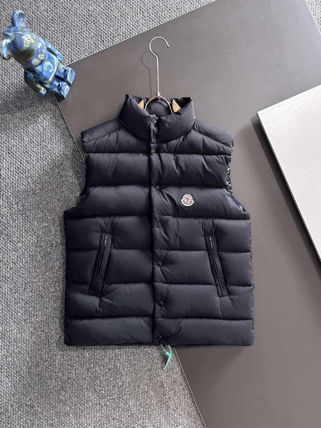 NO:629446,High version pay attention to details MOC25RFW new autumn and winter black matte nylon stand-up collar down vest, the same classic felt badge fashion warm down vest jacket for men and women!  The trading company channel is rarely available, and it is available for sale on the official website simultaneously for 10610RMB!  Fameng's new down vest uses high-end materials, exquisite craftsmanship and thoughtful design to bring you a dual experience of warmth and fashion!  In this cold season, wear it to make yourself the most dazzling presence on the street!   This vest is made of imported black matte nylon material. Compared with ordinary nylon fabrics, it is a little less ostentatious and shiny, but has a little more low-key and luxurious charm!  The contrasting paint nylon lining is ingeniously designed and has good breathability. Even in cold winters, the heat and moisture generated by the body can be quickly discharged, keeping the body dry and comfortable!  At the same time, it can also effectively prevent down from drilling out, avoiding the embarrassing situation that traditional down jackets tend to have, greatly improving the comfort of wearing it!  The interior is filled with high-quality 90% white duck down, and every feather is light and fluffy, as if it contains endless warm energy!  The designer cleverly used horizontal quilting technology to evenly fill the inside of the vest with white duck down. This grid filling method not only makes the vest look fuller and more stylish, but also effectively fixes the down to prevent it from accumulating or shifting during wearing!  The classic felt badge on the chest is beautifully designed and crafted with exquisite craftsmanship, and every detail is handled just right!  It not only adds a unique personality and sense of fashion to the vest, but also acts as a status symbol, highlighting the wearer's pursuit of quality and taste!  The placket adopts a four-button zipper double opening and closing method. This design not only ensures the firmness and sealing of the placket, but also makes it easier for the wearer to put on and take off!  When you zip up the zipper and fasten the snap button, the entire fly is like a solid line of defense, keeping the cold out!  All accessories are engraved with the brand logo, which not only reflects the brand's strict control of quality, but also highlights the brand's unique charm and cultural connotation!  The small stand-up collar design is simple yet elegant. It can not only protect the neck from the cold wind, but also show a capable and neat temperament!  The fitted version follows the curves of the body and is neither too loose and bulky nor too tight to restrict movement!  Sizes 1-5 Size 1 has a shoulder width of 44cm - bust 114cm - dress length 68cm Size 2 has a shoulder width of 45cm - bust 118cm - dress length 69cm Size 3 has a shoulder width of 46cm - bust 122cm - dress length 70cm Size 4 has a shoulder width of 47cm - bust 126cm - dress length 72cm Size 5 has a shoulder width of 48cm - bust cm - dress length 74cm Size recommendations (standard version)  Height 174-jin, tried on size 2 and it fits!  For boys, choose size 1 if you weigh less than 143 pounds, choose size 2 if you weigh -143 pounds, choose size 3 if you weigh 143-156 pounds, choose size 4 if you weigh 156-172 pounds, and choose size 5 if you weigh 172-188 pounds!  All girls can choose size 1!  ,,jackets & coats,down jacket,alexander wang19860909高版本 注意细节 MOC25RFW秋冬新款黑色哑光尼龙立领羽绒马甲,男女同款经典毛毡徽章时尚保暖羽绒马甲外套！贸易公司渠道稀出,同步官网发售10610RMB！法蒙家新款羽绒马甲奉献,采用高级的材质、精湛的工艺和贴心的设计,为你带来温暖与时尚的双重体验！在这个寒冷的季节里,穿上它让自己成为街头最耀眼的存在！  该马甲采用客供进口黑色哑光尼龙材质,与普通的尼龙面料相比,它少了几分张扬的光泽,却多了几分低调而奢华的韵味！撞色漆面尼龙内衬,设计堪称巧妙,具有良好的透气性,即使在寒冷的冬日里,身体产生的热气和湿气也能迅速排出,保持身体的干爽舒适！同时它还能有效防止羽绒钻出,避免了传统羽绒服容易出现钻绒的尴尬情况,大大提升了穿着的舒适性！内里选用了优质的90白鸭绒作为填充物,每一根羽毛都轻盈蓬松,仿佛蕴含着无尽的温暖能量！设计师巧妙地采用了横向绗缝技术,将白鸭绒均匀地分格填充在马甲内部,这种分格填充的方式不仅让马甲看起来更加饱满有型,还能有效地固定羽绒,防止其在穿着过程中出现堆积或移位的情况！ 胸前经典毛毡徽章,设计精美工艺精湛,每一个细节都处理得恰到好处！它不仅为马甲增添了一份独特的个性和时尚感,更像是一种身份的象征,彰显着穿着者对品质和品味的追求！门襟采用了四合扣拉链双重开合的方式,这种设计既保证了门襟的牢固性和密封性,又方便了穿着者的穿脱！当你拉上拉链,再扣上四合扣,整个门襟就像一道坚固的防线,将寒冷隔绝在外！所有的辅料均刻有品牌 Logo,这不仅体现了品牌对品质的严格把控,更彰显了品牌的独特魅力和文化内涵！小立领设计简约而不失优雅,既能很好地保护颈部免受寒风的侵袭,又能展现出一种干练利落的气质！合体的版型则贴合身体曲线,既不会过于宽松显得臃肿,也不会过于紧身限制活动！尺码1-5 1码肩宽44cm-胸围114cm-衣长68cm 2码肩宽45cm-胸围118cm-衣长69cm 3码肩宽46cm-胸围122cm-衣长70cm 4码肩宽47cm-胸围126cm-衣长72cm 5码肩宽48cm-胸围cm-衣长74cm 尺码推荐（标准版型） 身高174-斤,试穿2码合适！ 男生体重斤以内选择1码,-143斤选择2码,143-156斤选择3码,156-172斤选择4码,172-188斤选择5码！ 女生全部选择1码即可！,,jackets & coats,down jacket,alexander wang,Men's clothing