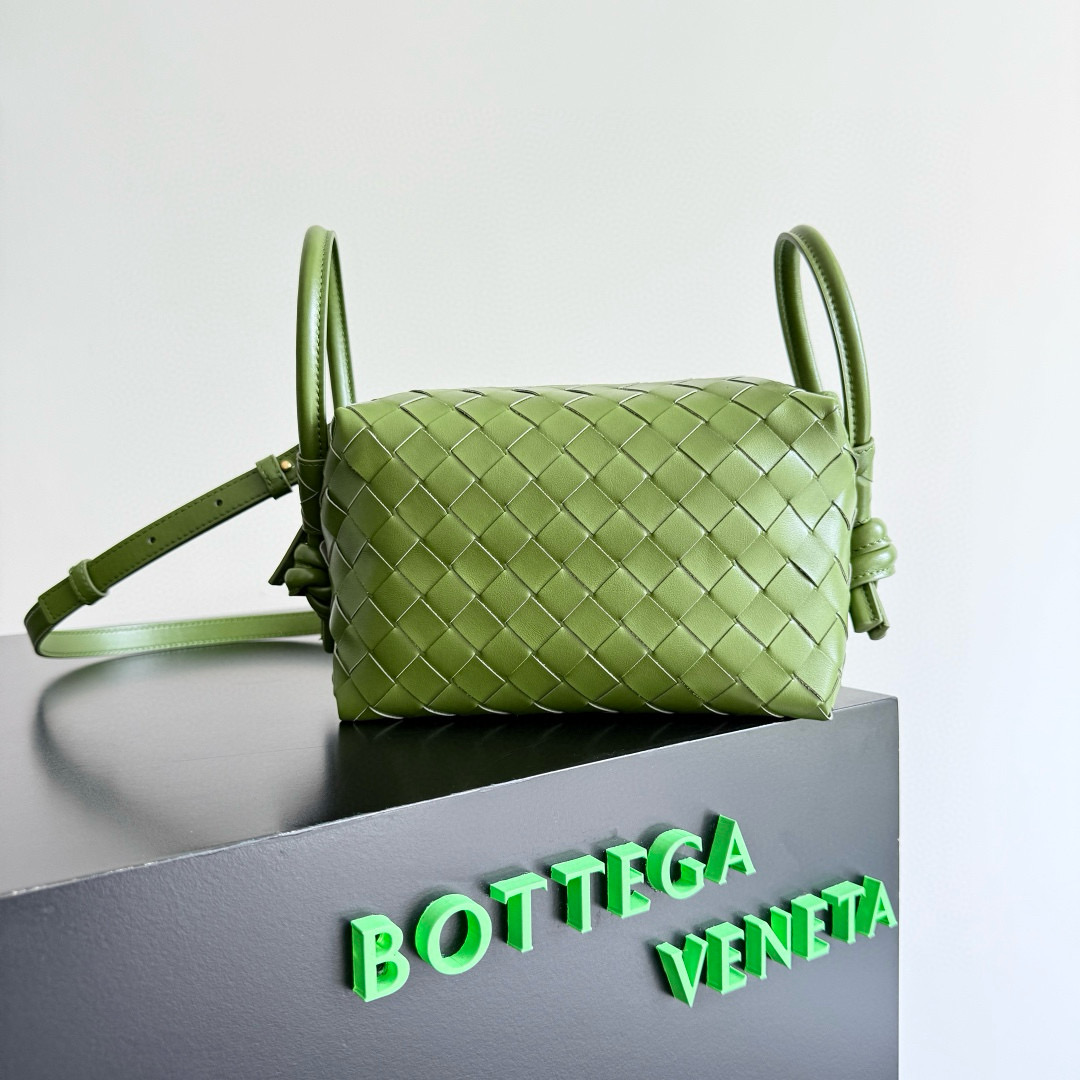 The BOTTEGA VENETA 2024 new Loop is here! Many BV fans have owned the Loop bag—simple design, classic weaving, compact and lightweight. This innovation continues the "camera bag" style but now allows both hand-carry and crossbody wear, unlike the traditional Loop which was only crossbody. The oversized ring clasp lets you fold the bag or use it as a handle. Perfect for summer, this lightweight bag boosts your travel comfort.  
Style number: 796615  
Size: 19 x 12 x 9 cm image 1