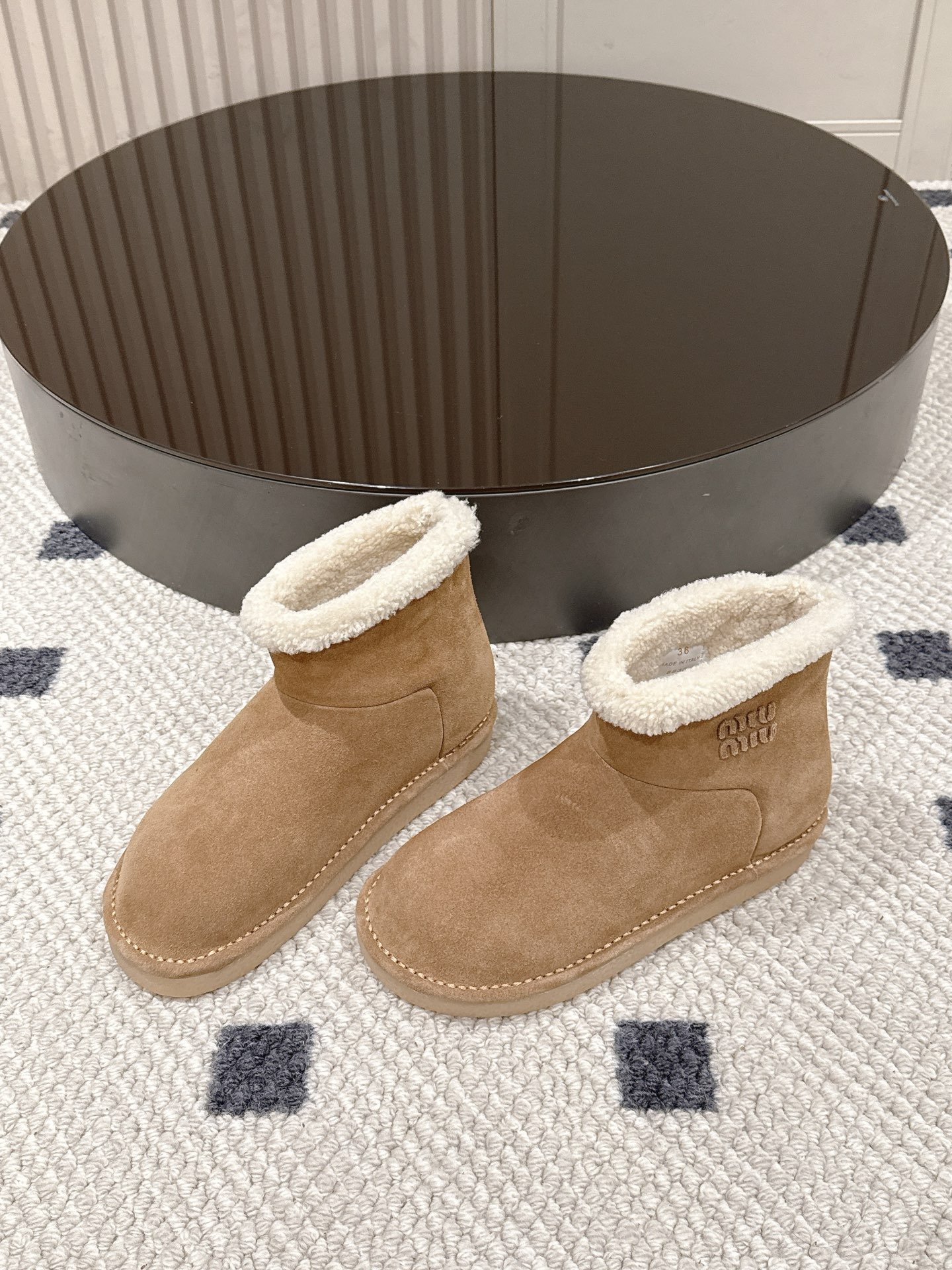 p280码数35-40！
Miu Miu 25FW 羊毛雪地靴
这是一款雪地靴，有浅米色和深棕色和黑色等款式。外观上，鞋面采用质感细腻的反绒皮材质，鞋口处环绕着一圈蓬松柔软的白色毛绒，既增添了时尚感，又能很好地包裹脚踝，起到保暖作用。
搭配方面，浅米色款可与浅色系的牛仔裤、针织裙搭配，打造出清新温柔的冬日造型；深棕色款则适合和深色系的工装裤、毛呢裙组合，营造出复古又温暖的风格，无论是日常出街还是冬日通勤，都很合适。