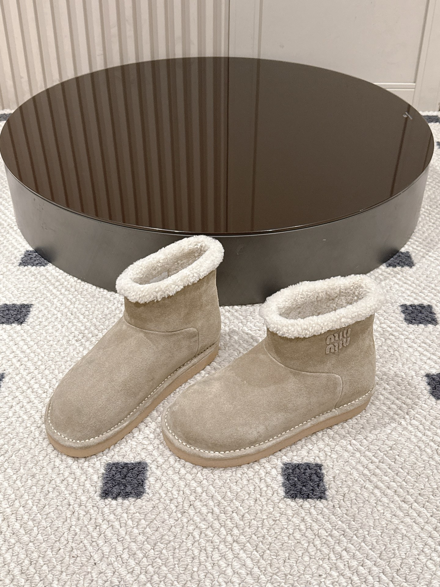 p280。码数35-40！
Miu Miu 25FW 羊毛雪地靴
这是一款雪地靴，有浅米色和深棕色和黑色等款式。外观上，鞋面采用质感细腻的反绒皮材质，鞋口处环绕着一圈蓬松柔软的白色毛绒，既增添了时尚感，又能很好地包裹脚踝，起到保暖作用。
搭配方面，浅米色款可与浅色系的牛仔裤、针织裙搭配，打造出清新温柔的冬日造型；深棕色款则适合和深色系的工装裤、毛呢裙组合，营造出复古又温暖的风格，无论是日常出街还是冬日通勤，都很合适。