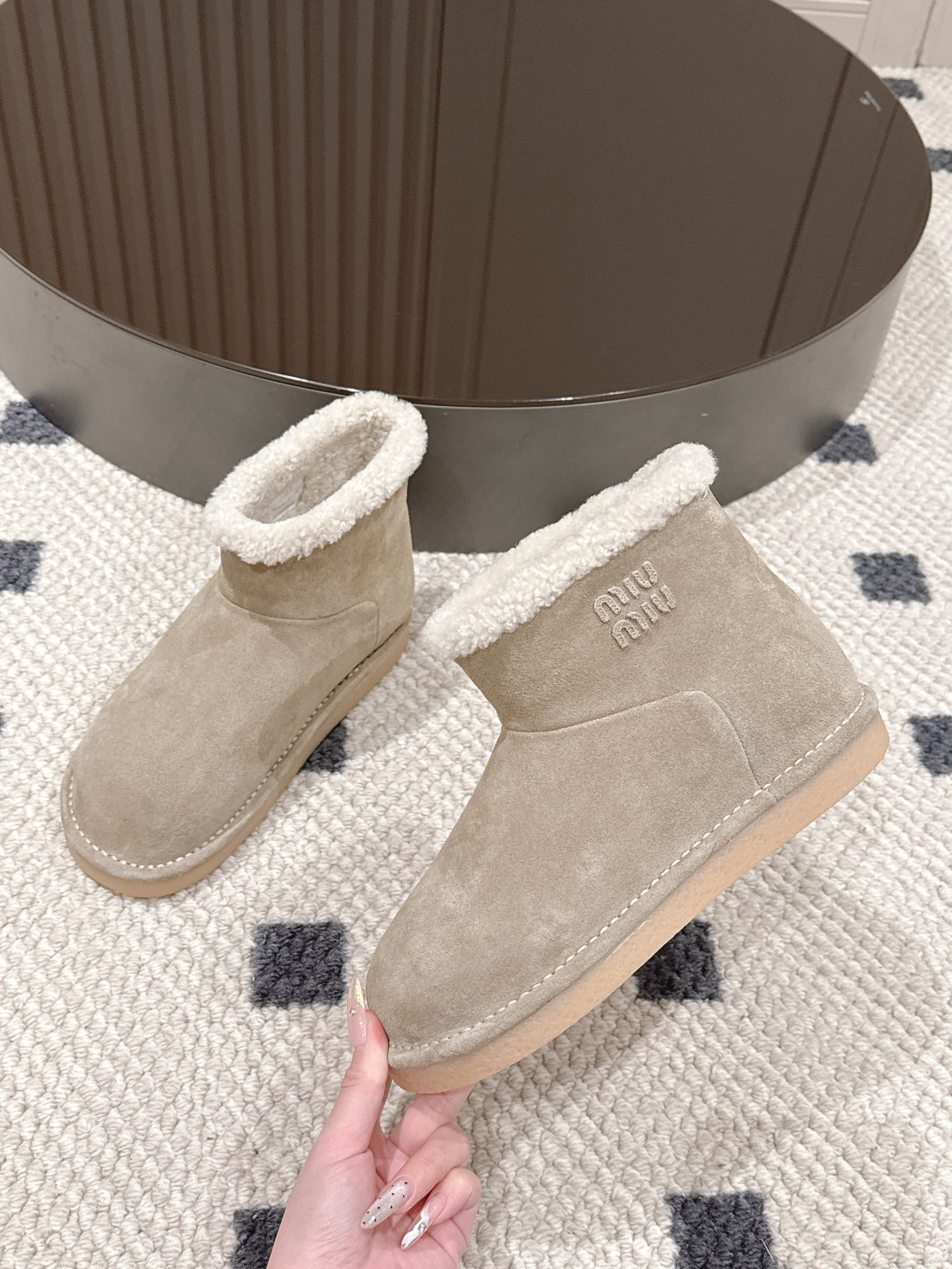 p280。码数35-40！
Miu Miu 25FW 羊毛雪地靴
这是一款雪地靴，有浅米色和深棕色和黑色等款式。外观上，鞋面采用质感细腻的反绒皮材质，鞋口处环绕着一圈蓬松柔软的白色毛绒，既增添了时尚感，又能很好地包裹脚踝，起到保暖作用。
搭配方面，浅米色款可与浅色系的牛仔裤、针织裙搭配，打造出清新温柔的冬日造型；深棕色款则适合和深色系的工装裤、毛呢裙组合，营造出复古又温暖的风格，无论是日常出街还是冬日通勤，都很合适。