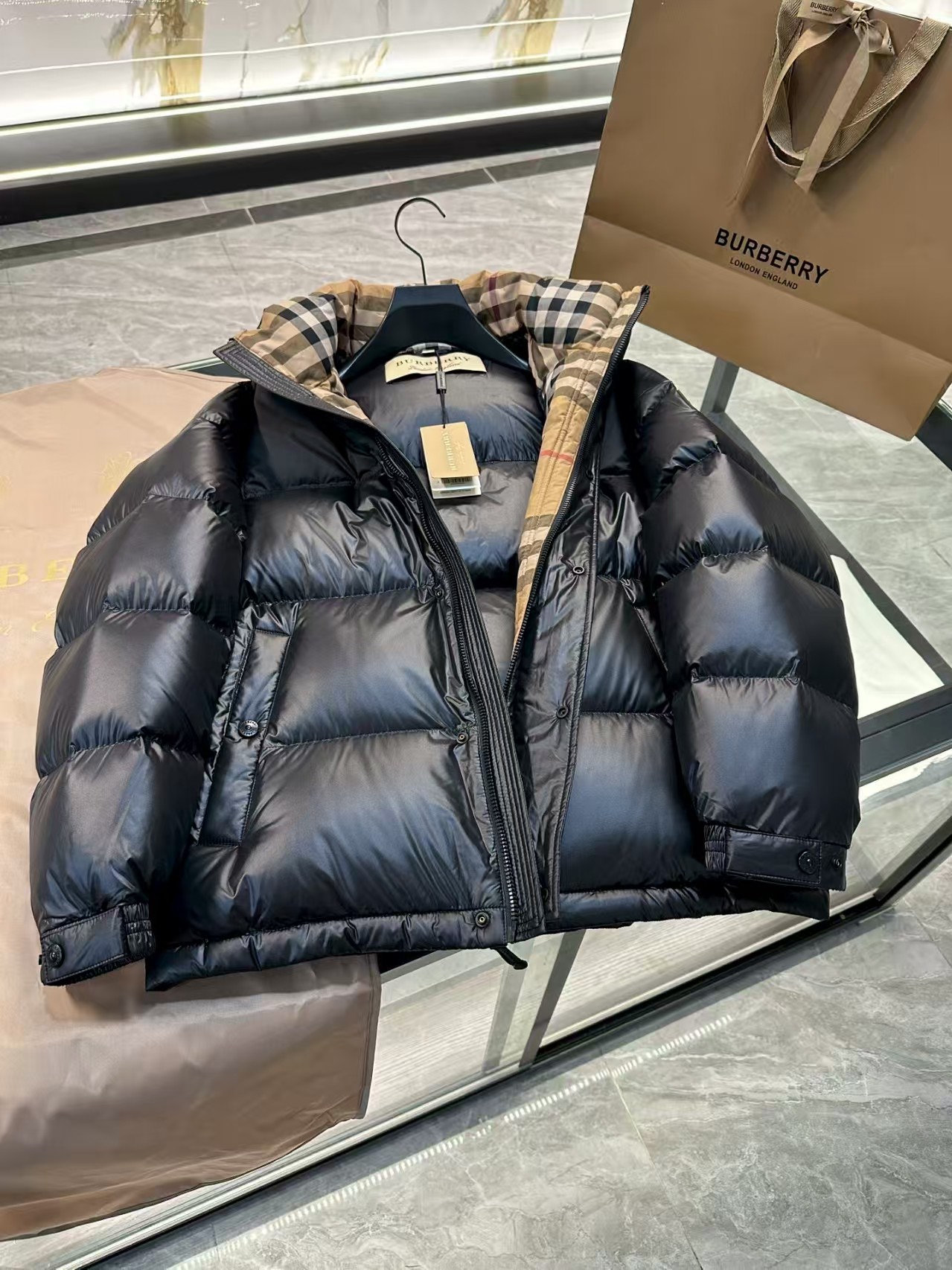 💰390 顶级代购版本
Burber* 撞色胶条字母Logo徽标连帽羽绒服.内里拼接经典格纹内衬,上身效果真的绝.特级鹅绒填充.填充超级饱满.
强烈推荐!!!!	这款上身效果真绝了!	
商品描述
-双向拉链开合 -侧边隐藏式口袋 -侧边拉链口袋 -抽绳式衣摆 -防风袖口
- 连帽防风高领
-肩标B字型拼色胶条logo
-休闲版型:较常规版型剪裁更为宽松，请选择小一号尺码。面料与保养
-外层:100%聚酰胺
-装饰:88%棉，11%聚酰胺，1%弹性纤维 -内衬: 100%聚酰胺
-填充:鸭绒，鸭毛;绒子含量 90% -填衬:100%聚酯纤维
Size:48-56