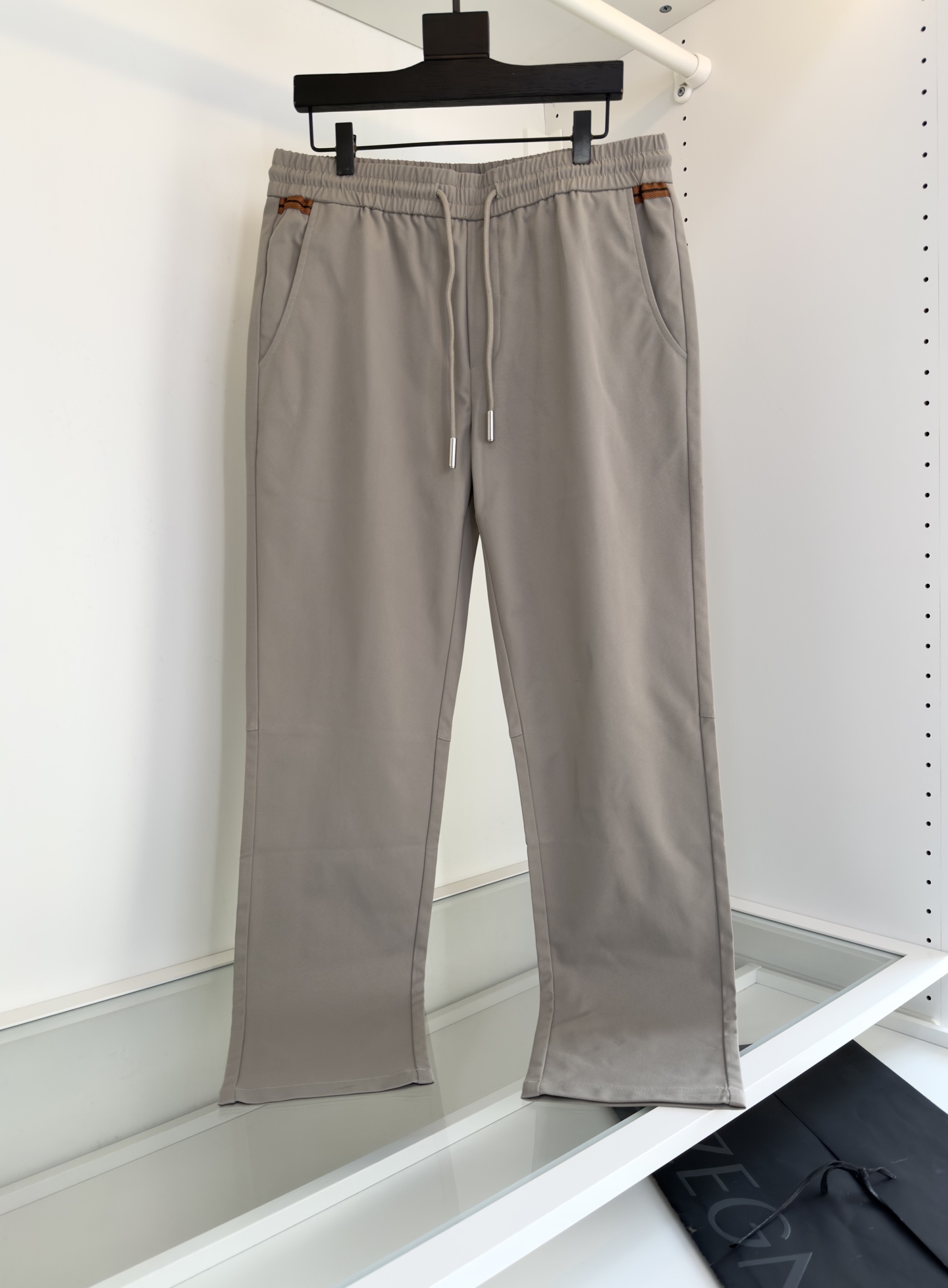 NO:513012,Zeg*a Jie*ya Spring and Summer 2005 new style, lightweight twill cotton drawstring casual pants, men's two-color webbing back pocket fashionable and versatile casual pants!  Trading companies have sparse channels and are on sale on the leading official website!  With its unique design and selected fabrics, this new casual pants in Z home have become a model of both fashion and comfort!  The fabric is made of customized light and thin twill cotton cloth, which is not only light in texture, but also as refreshing as the summer breeze, but also has a crisp and drooping feeling, revealing the natural and smooth line beauty while walking!  The design of the waist of the pants is unique, and the two sides and the back pockets are cleverly integrated into the classic two-color webbing element splicing. This detail not only adds to the layering of the pants, but also forms a unique rhythmic beauty visually!  The color matching of the webbing is just right, not too ostentatious and individual, showing the brand's unique low-key luxury!  At the same time, the addition of the three-dimensional offset logo is the finishing touch, making the whole pants reveal extraordinary brand charm in simplicity!  In order to meet the wear needs of different groups of people, this casual pants adopts a drawstring elastic waist design, which is not only convenient for putting on and taking off, but also freely adjusting the tightness according to the individual waist size to ensure comfort and fit during wear!  The casual straight-tube cutting method, this style not only modifies the leg shape well, lengthens the leg lines, making the wearer look taller and taller!  And you can move freely, whether it is a long-term office or an outdoor adventure, you can keep your comfort and freedom all day long!  Color Khaki Blue, code number M-3XL is suitable for wearing L size 172-148, alexander wang19860909Zeg*a杰*亚 2005春夏新款 轻薄斜纹棉质抽绳休闲裤,男士双色织带后兜时尚百搭休闲长裤！贸易公司渠道稀出,领先官网发售！这款Z家全新休闲裤,以其独特的设计和精选的面料,成为了时尚与舒适并重的典范！面料采用客供定制轻薄斜纹棉布,不仅质地轻盈,如同夏日微风拂面般清爽,而且挺括有垂感,行走间流露出自然流畅的线条美！裤腰的设计更是别出心裁,两侧及后兜巧妙地融入了经典的双色织带元素拼接,这一细节不仅增添了裤子的层次感,更在视觉上形成了一种独特的韵律美！织带的颜色搭配恰到好处,既不过分张扬,又不失个性,彰显出品牌独有的低调奢华！与此同时立体胶印标识的加入,更是点睛之笔,使得整款裤子在简约中透露出不凡的品牌魅力！为了满足不同人群的穿着需求,这款休闲裤采用了抽绳松紧裤腰的设计,不仅方便穿脱,更能够根据个人的腰围大小自由调节松紧度,确保穿着时的舒适与贴合！休闲直筒的裁剪方式,这种版型不仅能够很好地修饰腿型,拉长腿部线条,使得穿着者看起来更加高挑挺拔！而且活动自如,无论是久坐办公还是户外探险,都能保持整日的舒适与自在！颜色 卡其 蓝色, 码数M-3XL试穿172-148穿L码合适,,alexander wang,Men's clothing