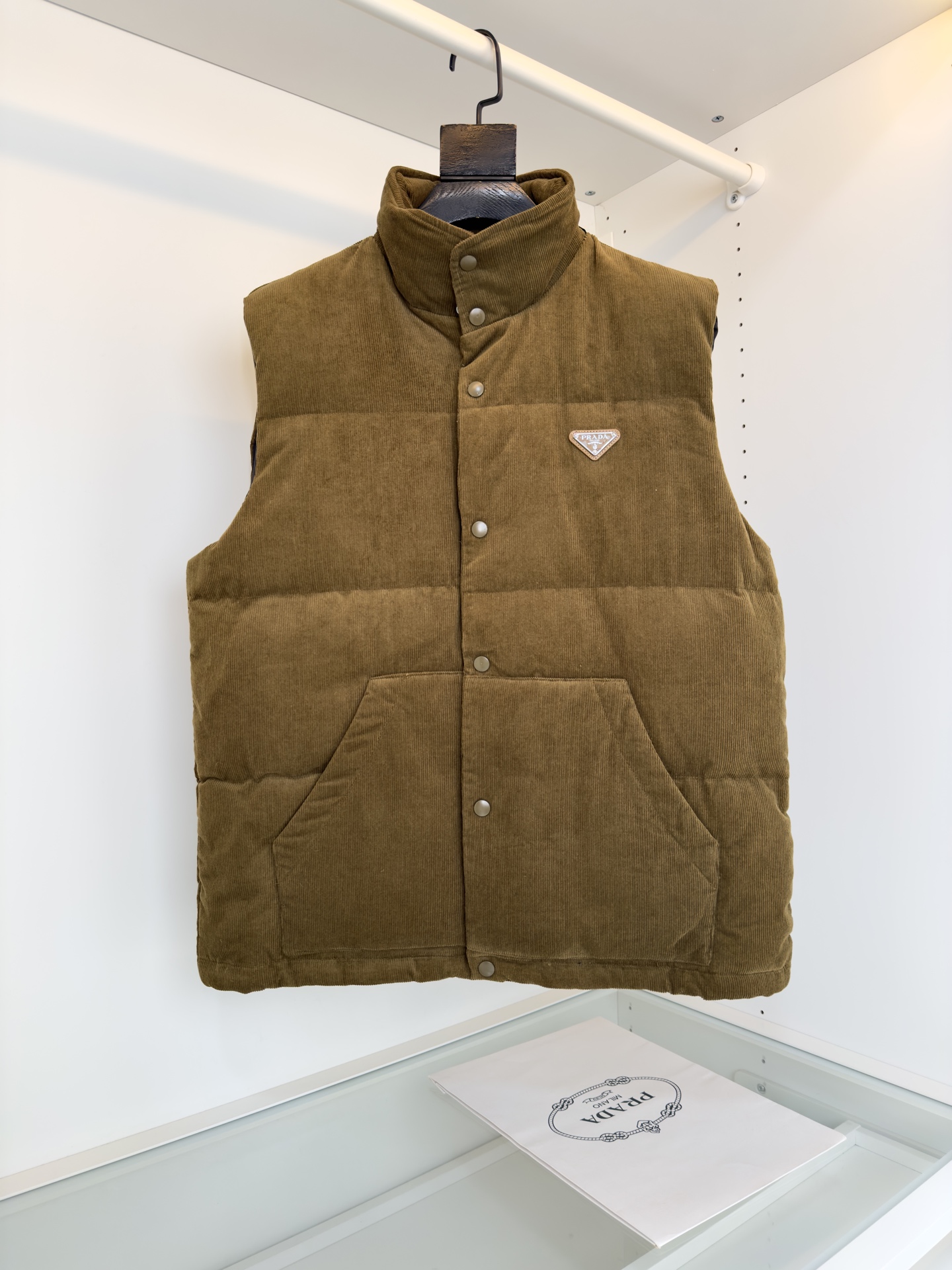 NO:655772,.Pr*da 2025 autumn and winter cabinets are on sale!  Fashionable retro style Corduroy down vest Classic stand-up collar style Triangular logo embellishment on the chest Invisible hood Pockets on both sides Fitted tailoring The fabric is made of custom-woven corduroy material, with three-dimensional and warm pit details on the surface of the fabric. It has a retro and nostalgic tone visually, with a little 70s feel mixed in, giving people a lazy and relaxed feeling!  The delicate and smooth fiber lining inside is filled with 90% white goose down. It has sufficient down filling and is free of stems and clumps. It has a full and soft down texture. It rebounds instantly when pressed. It can effectively lock in and gather body temperature, bringing you the warmest and most comfortable wearing experience!  The basic and conventional stand-up collar vest style cutting, simple and neat design, can easily create a fashionable and elegant casual look!  Color Black Brown Size S-XL Try on 172-148, wear M size for a slim fit, down jacket, hats, alexander wang19860909.Pr*da普*达 2025秋冬 柜在售！ 时尚复古腔调 灯芯绒羽绒马甲 经典的立领款式 胸口三角标Logo点缀 隐形帽 两侧插袋 合体的剪裁 面料采用 客供定织灯芯绒材质制作而成,面料表面立体温润的坑条细节,视觉上自带复古怀旧腔调,骨子里混了些许70年代的feel,给人慵懒放松的感觉！内里细腻爽滑的纤维内衬,搭配90白鹅绒填充,充绒量足且无梗不结块,饱满柔软的羽绒质感,按压下去瞬间回弹,着身可以有效的锁温聚温,带来最保暖舒适的着穿体验！基础常规的立领马甲版型裁剪,简洁利落的设计,可轻松打造时尚大气的休闲造型！ 颜色 黑色 咖色 尺码S-XL 试穿172-148穿M码修身感,,down jacket,hats,alexander wang,Men's clothing