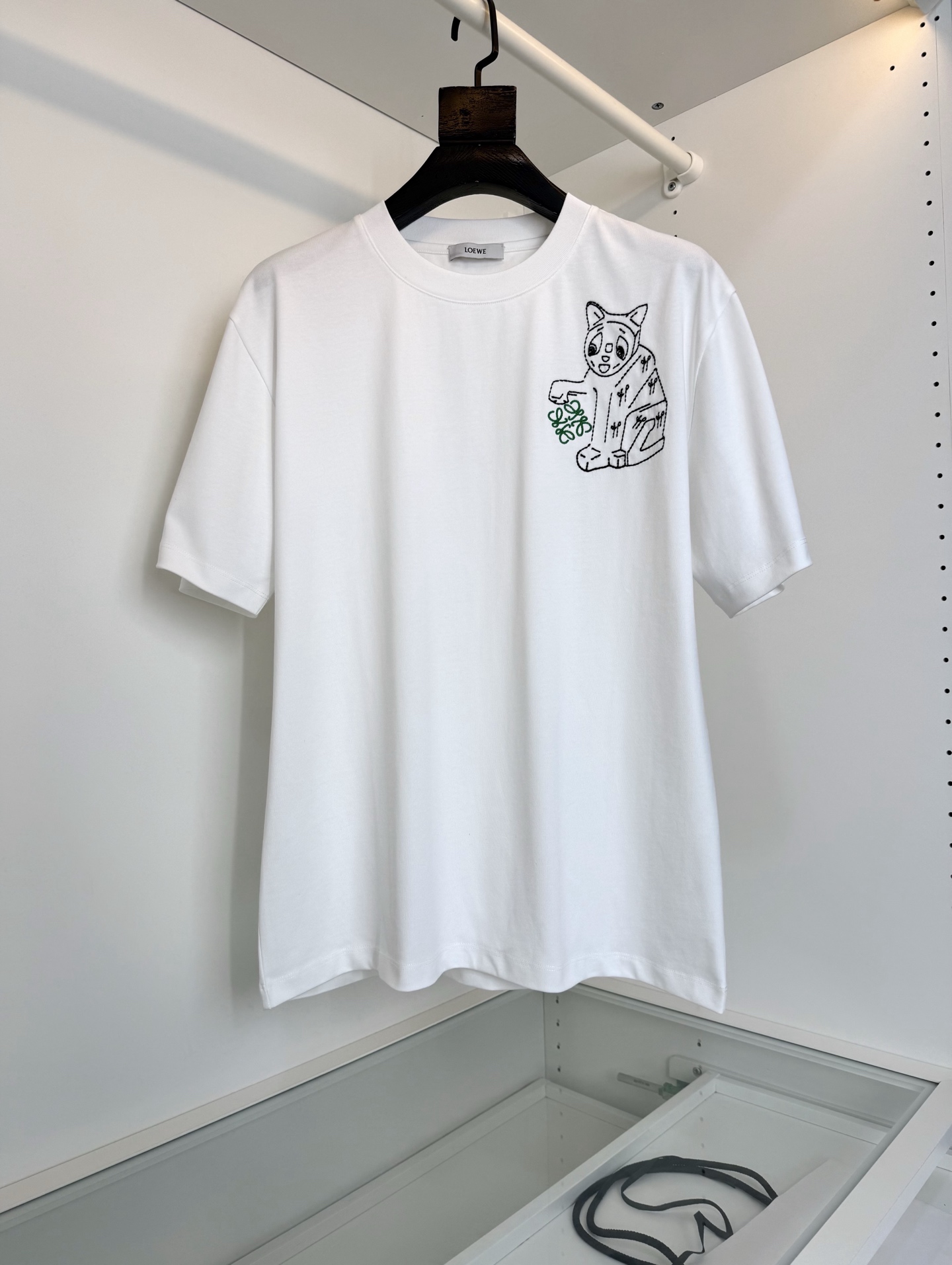 NO:743269,The highest version on the market, the girl will inspect the goods, trim the three marks on the threads, and ship the goods. You can post pictures and take videos. If you want quality and service, please add me on WeChat. We will not accept urgent orders. L**WE 2026 spring and summer new style, joint series, slightly wide embroidered round neck short-sleeved T-shirt with cat eye and Anagram embroidery on the chest. The T-shirt is inspired by Louis Wain's 'Futurist Cats'  Ceramic vase series. Embroidered by imported Behringer embroidery machine. Pattern-making by a master with more than ten years of experience. Every stitch is very delicate. Look at the details. The pattern is fine and textured, which makes the whole body high-end and detailed. Trading company order. Fitted tailoring. The fabric is made of high-count pure cotton. The upper body is comfortable and breathable, and the overall body has a good sense of stiffness. The whole product is in order. [Color] Black White [Size] M-3XL  Try on 172-148, suitable for L, Loewe-clothing, louis vuitton, loewe, T-shirt, tees, t-shirt,19860909市面最高版本小妹验货、修剪线头上三标、发货可发图及拍视频,要品质要服务的加我微信,不接急单. 罗*威L**WE 2026春夏新款,联名系列 微阔刺绣圆领短袖T恤 胸前饰有猫眼和 Anagram 刺绣.T 恤灵感源自 Louis Wain 的 “Futurist Cats” 陶瓷花瓶系列.,进口百灵达绣花机刺绣.十几年的老师傅 制版 一针一线非常精致 看细节 图案精细而显质感 让整体高档而有细节感 贸易公司订单 合体的剪裁 面料采用高支纯棉质地,上身舒适透气,整体又有很好的挺括感,全品相订单【颜色】黑色 白色 【码数】M-3XL 试穿172-148穿L合适,罗意威-服装,louis vuitton,loewe,T-shirt,tees，t-shirt,,Women's clothing