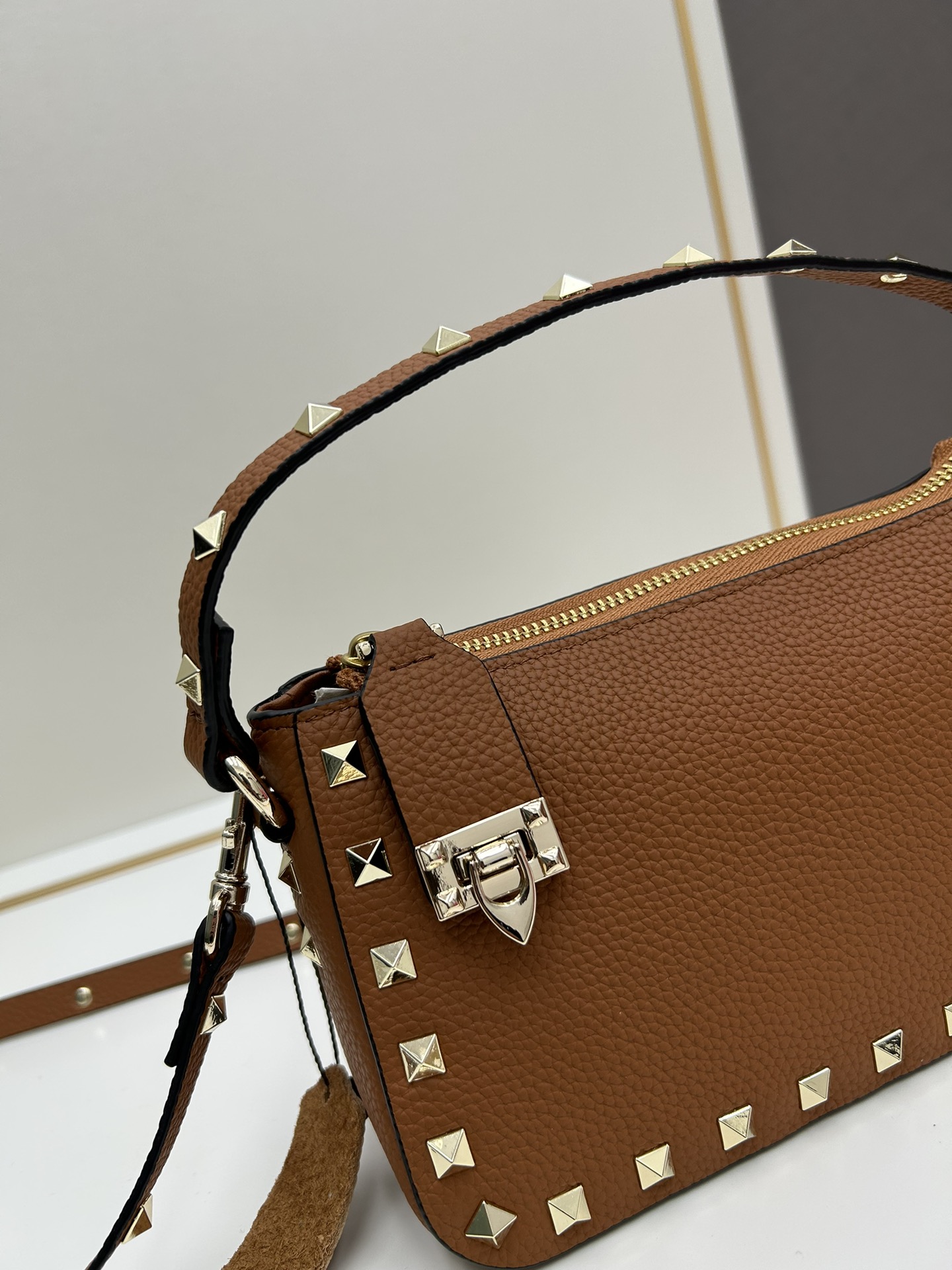 valent*** Garavani Rockstud 小号牛皮斜挎包，标志性的钩扣开合设计经重新诠释，