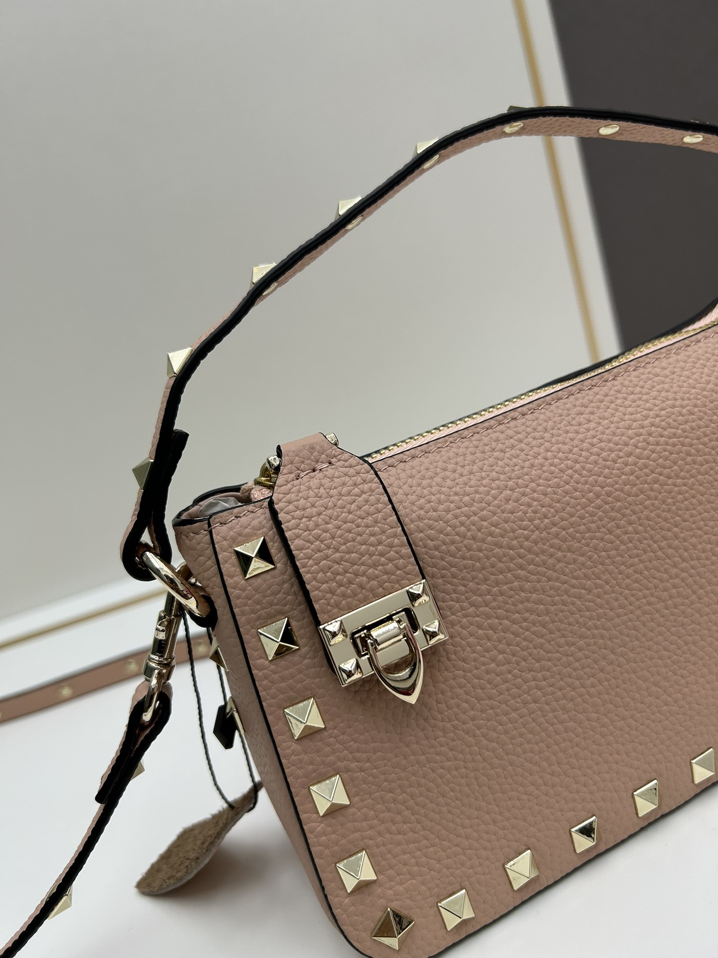 valent*** Garavani Rockstud 小号牛皮斜挎包，标志性的钩扣开合设计经重新诠释，