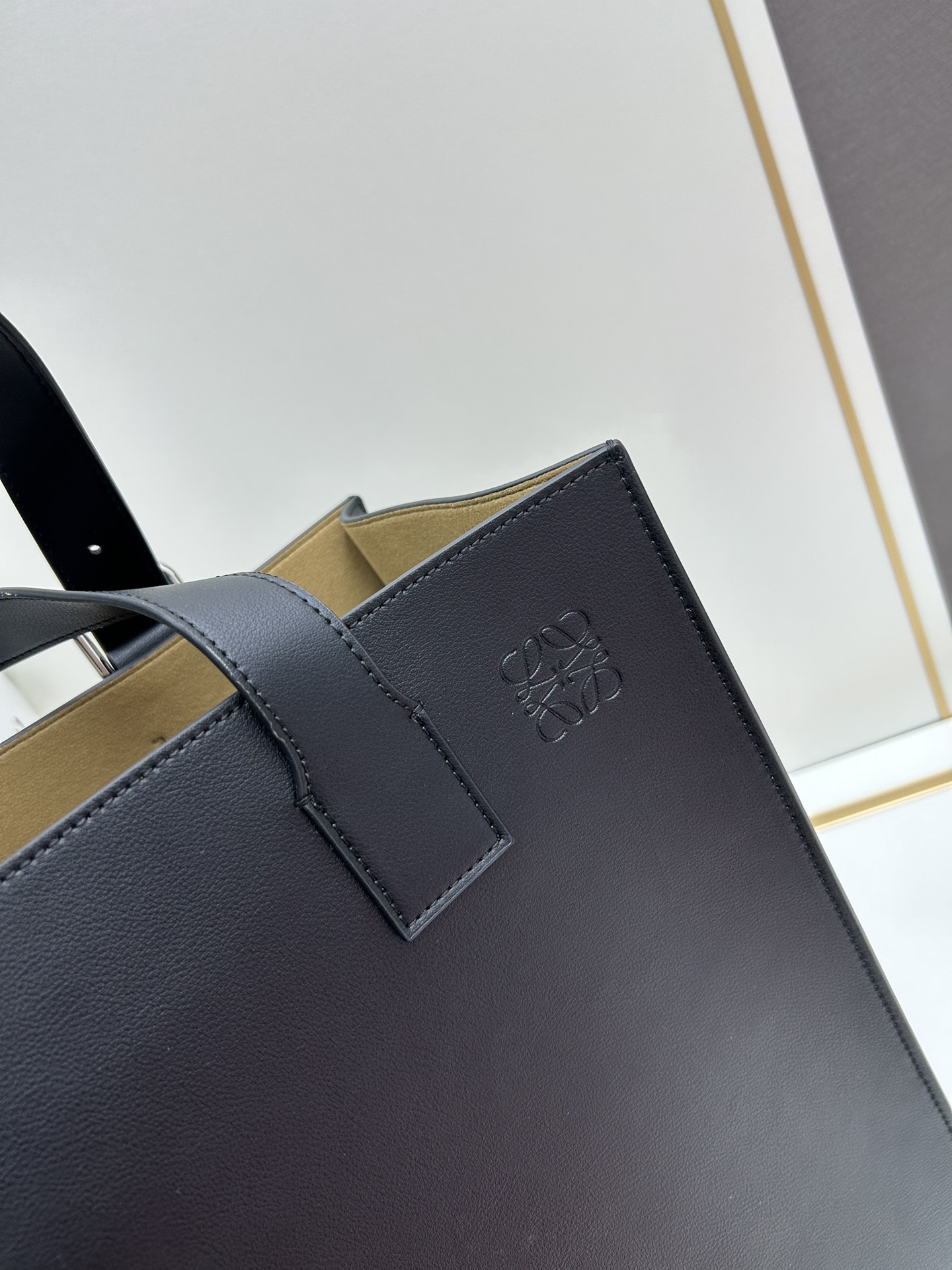 780 Loewe Buckle Tote 不带拉链 荔枝纹深灰手袋 男仕灰色托特包，型號3050 宽大的容量和纤细的轮廓。扁平和不对称的双顶部手柄，饰有标志性的弧形开口搭扣，可通过链扣调节，适合不同的携带方式。主要特点：偏宽扁平矩形包身，内部拉链口袋，两个缝合插袋隔层，真皮里里，Anagram压印点缀 尺寸36-33-17cm