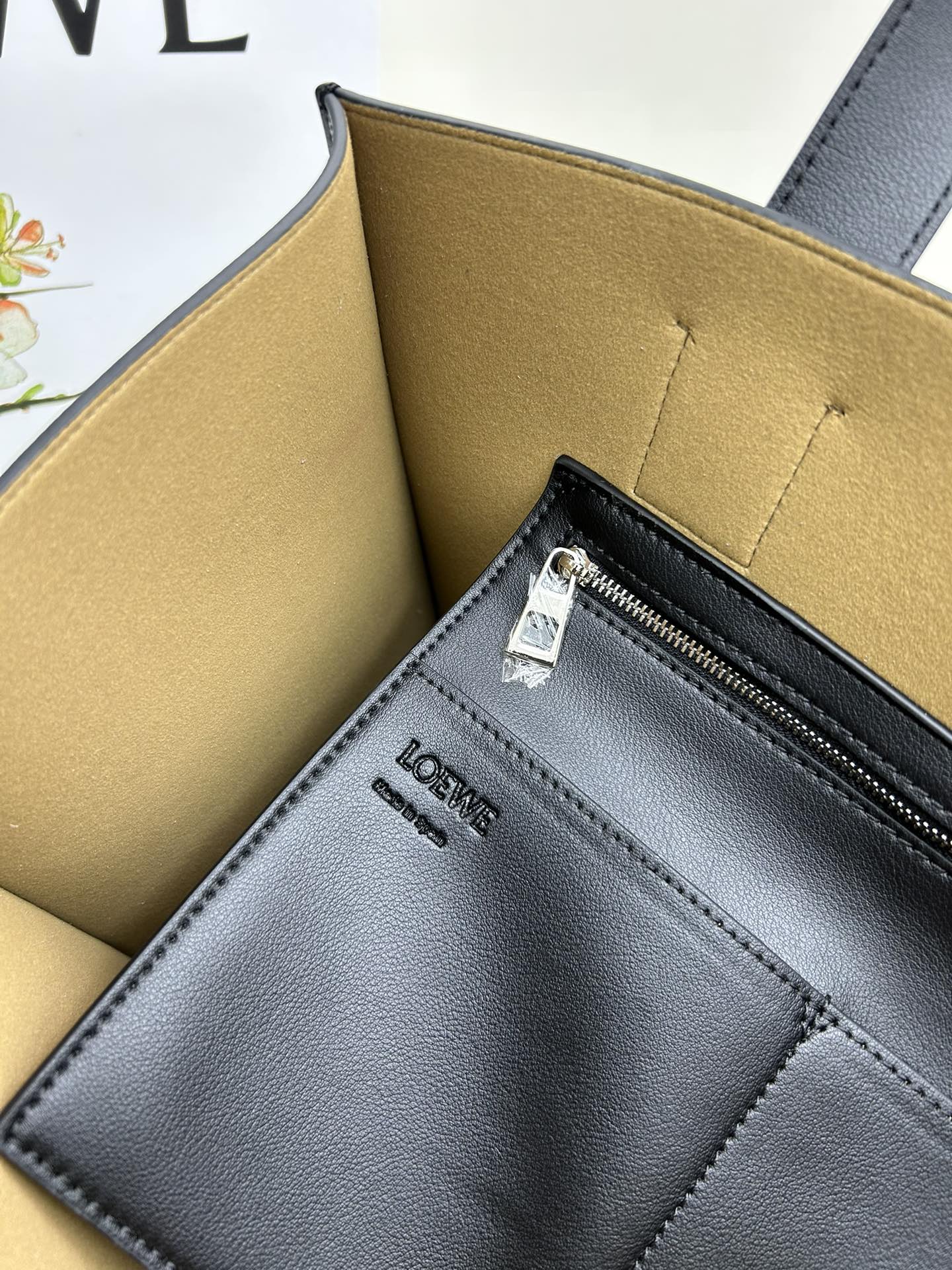 780 Loewe Buckle Tote 不带拉链 荔枝纹深灰手袋 男仕灰色托特包，型號3050 宽大的容量和纤细的轮廓。扁平和不对称的双顶部手柄，饰有标志性的弧形开口搭扣，可通过链扣调节，适合不同的携带方式。主要特点：偏宽扁平矩形包身，内部拉链口袋，两个缝合插袋隔层，真皮里里，Anagram压印点缀 尺寸36-33-17cm