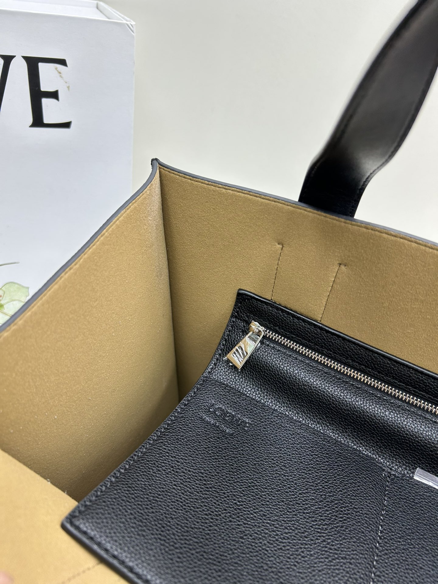 780 Loewe Buckle Tote 不带拉链 荔枝纹深灰手袋 男仕灰色托特包，型號3050 宽大的容量和纤细的轮廓。扁平和不对称的双顶部手柄，饰有标志性的弧形开口搭扣，可通过链扣调节，适合不同的携带方式。主要特点：偏宽扁平矩形包身，内部拉链口袋，两个缝合插袋隔层，真皮里里，Anagram压印点缀 尺寸36-33-17cm