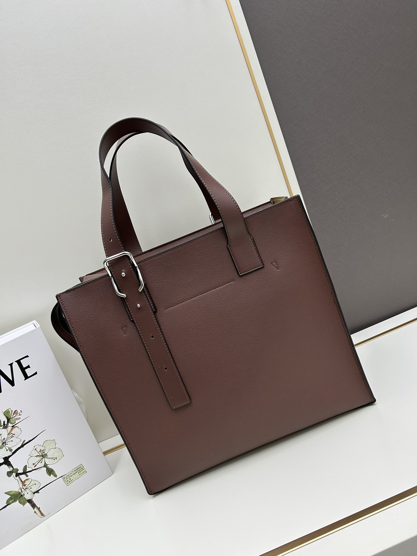 800 Loewe Buckle Tote手袋 新版本带拉链 
男仕托特包，型號3050A
宽大的容量和纤细的轮廓。扁平和不对称的双顶部手柄，饰有标志性的弧形开口搭扣，可通过链扣调节，适合不同的携带方式。主要特点：偏宽扁平矩形包身，内部拉链口袋，两个缝合插袋隔层，真皮里里，Anagram压印点缀 
尺寸36-33-17cm