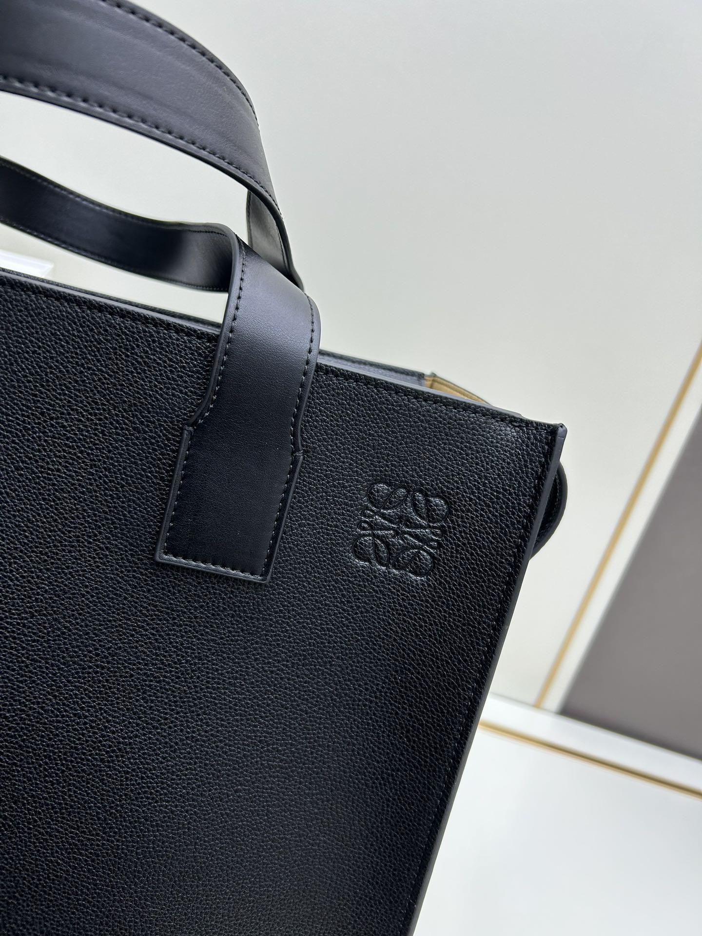 800 Loewe Buckle Tote手袋 新版本带拉链 
男仕托特包，型號3050A
宽大的容量和纤细的轮廓。扁平和不对称的双顶部手柄，饰有标志性的弧形开口搭扣，可通过链扣调节，适合不同的携带方式。主要特点：偏宽扁平矩形包身，内部拉链口袋，两个缝合插袋隔层，真皮里里，Anagram压印点缀 
尺寸36-33-17cm