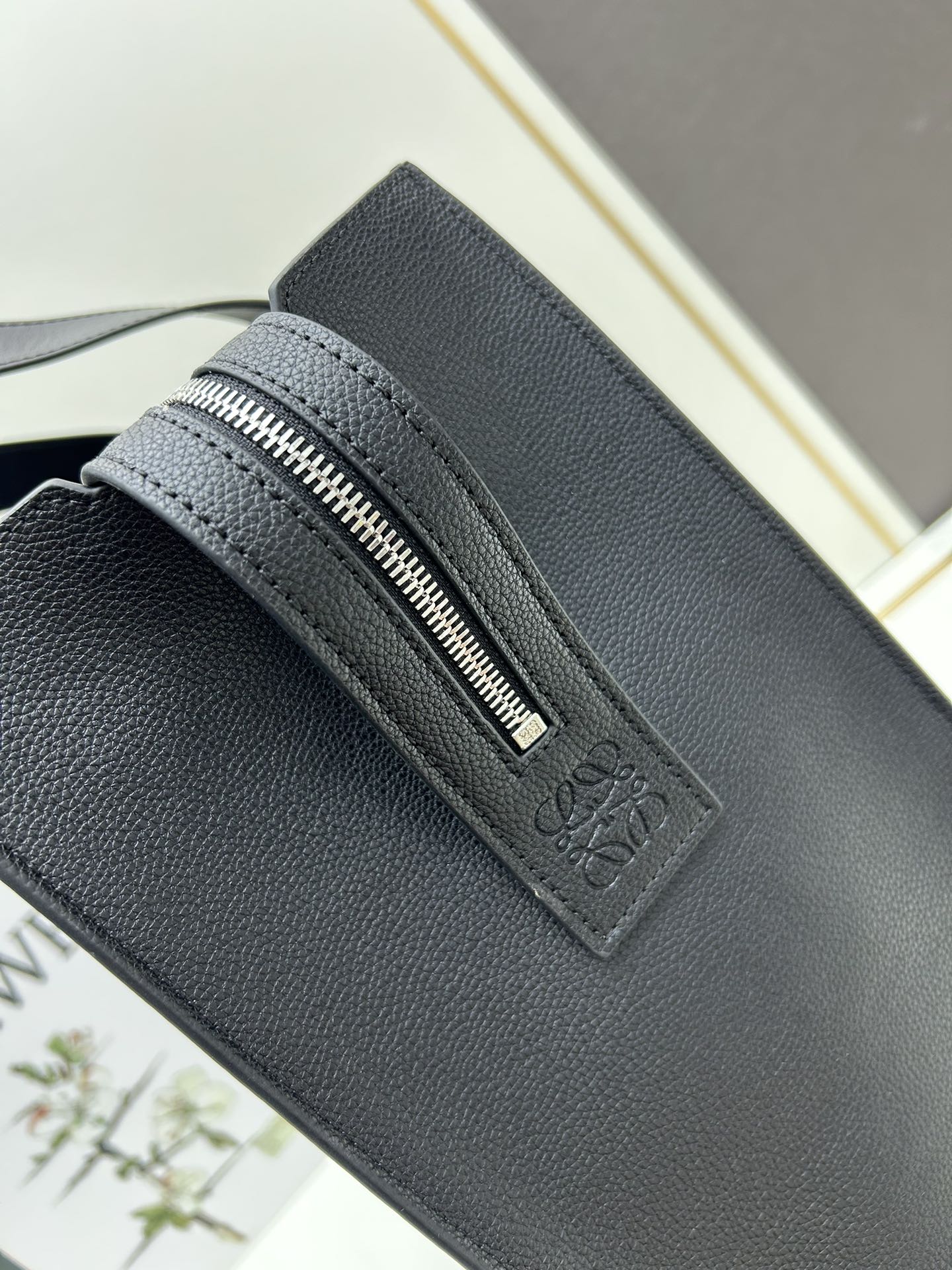 800 Loewe Buckle Tote手袋 新版本带拉链 
男仕托特包，型號3050A
宽大的容量和纤细的轮廓。扁平和不对称的双顶部手柄，饰有标志性的弧形开口搭扣，可通过链扣调节，适合不同的携带方式。主要特点：偏宽扁平矩形包身，内部拉链口袋，两个缝合插袋隔层，真皮里里，Anagram压印点缀 
尺寸36-33-17cm