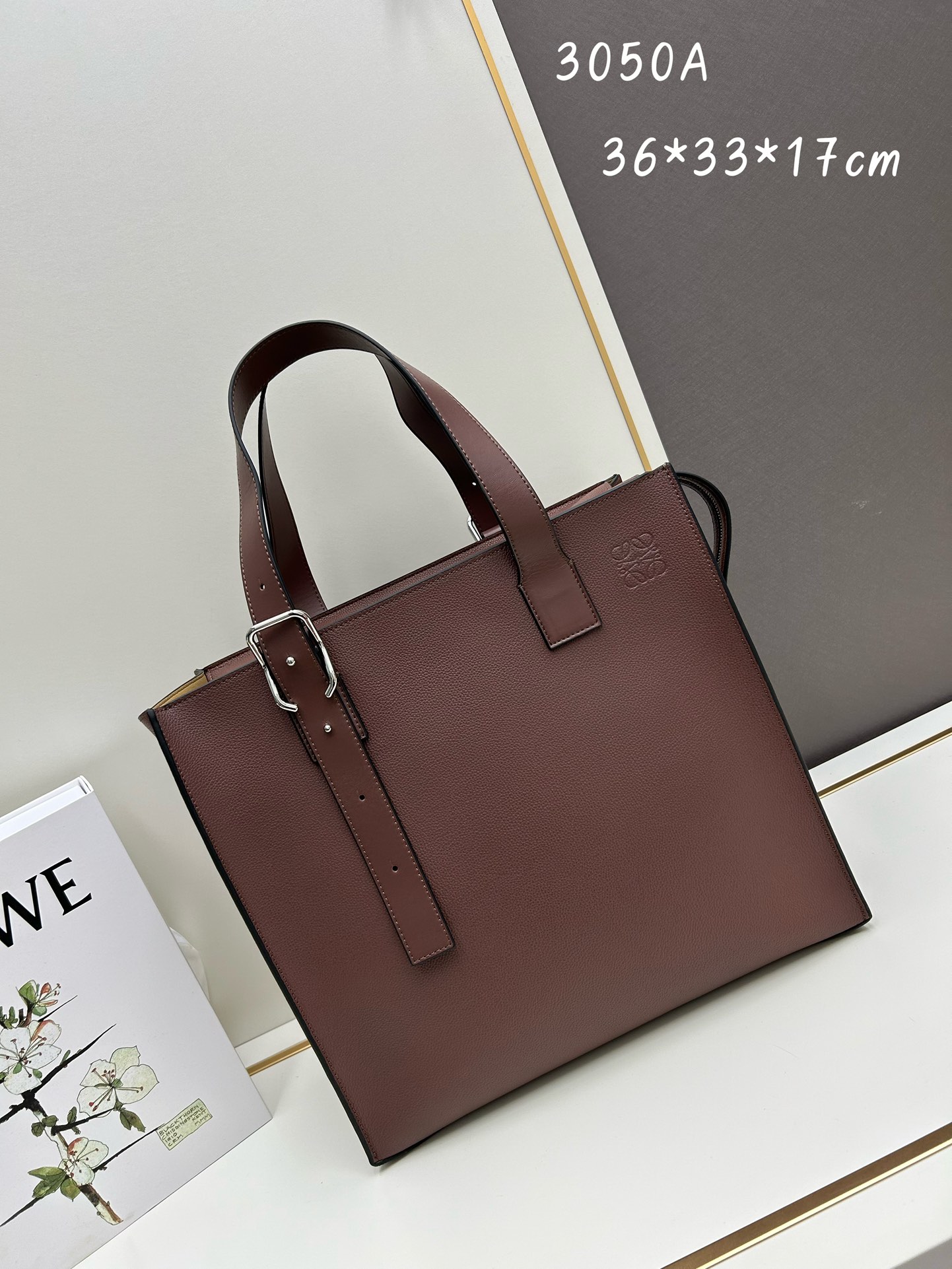 800 Loewe Buckle Tote手袋 新版本带拉链 
男仕托特包，型號3050A
宽大的容量和纤细的轮廓。扁平和不对称的双顶部手柄，饰有标志性的弧形开口搭扣，可通过链扣调节，适合不同的携带方式。主要特点：偏宽扁平矩形包身，内部拉链口袋，两个缝合插袋隔层，真皮里里，Anagram压印点缀 
尺寸36-33-17cm