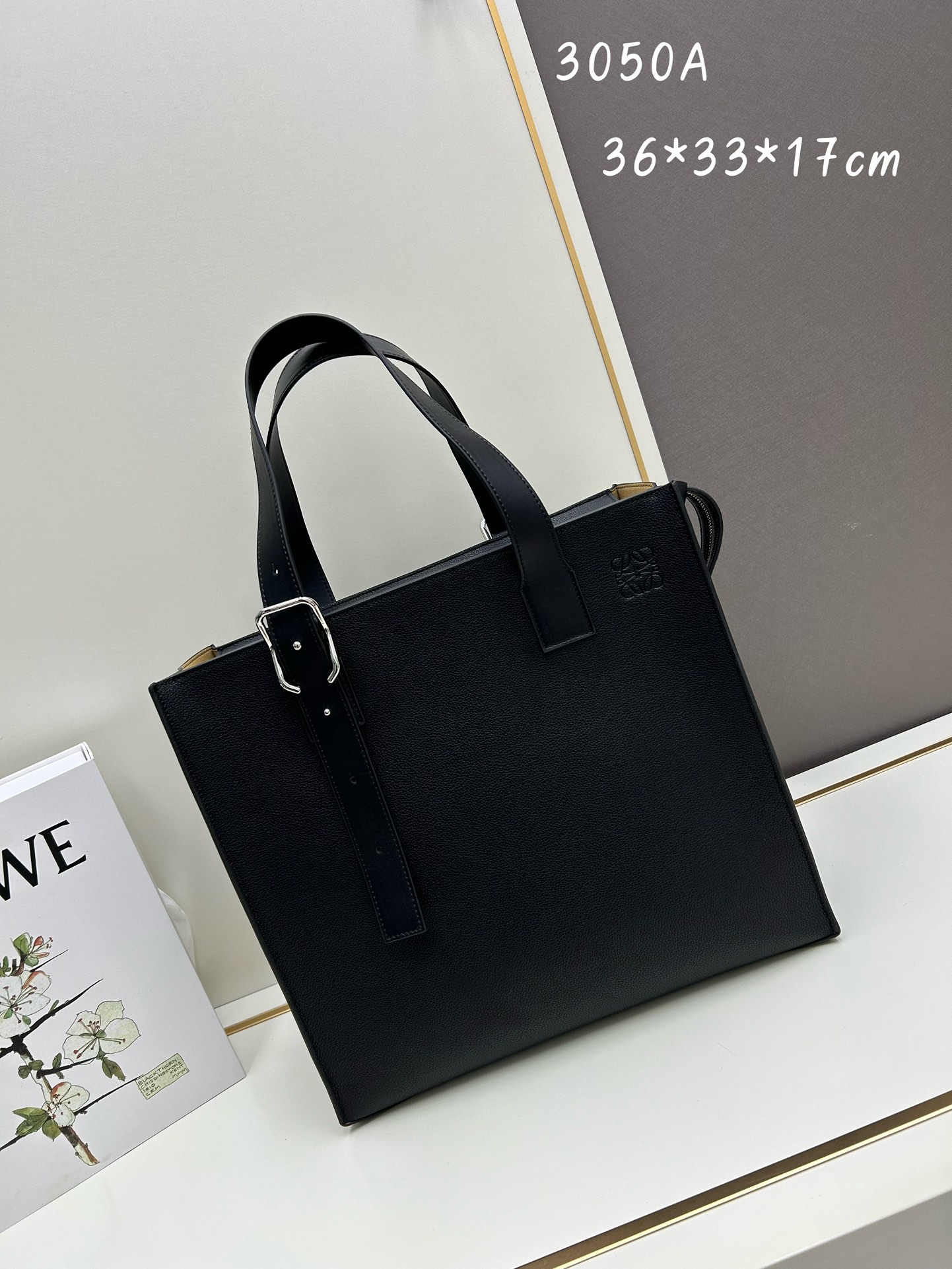 800 Loewe Buckle Tote手袋 新版本带拉链 
男仕托特包，型號3050A
宽大的容量和纤细的轮廓。扁平和不对称的双顶部手柄，饰有标志性的弧形开口搭扣，可通过链扣调节，适合不同的携带方式。主要特点：偏宽扁平矩形包身，内部拉链口袋，两个缝合插袋隔层，真皮里里，Anagram压印点缀 
尺寸36-33-17cm