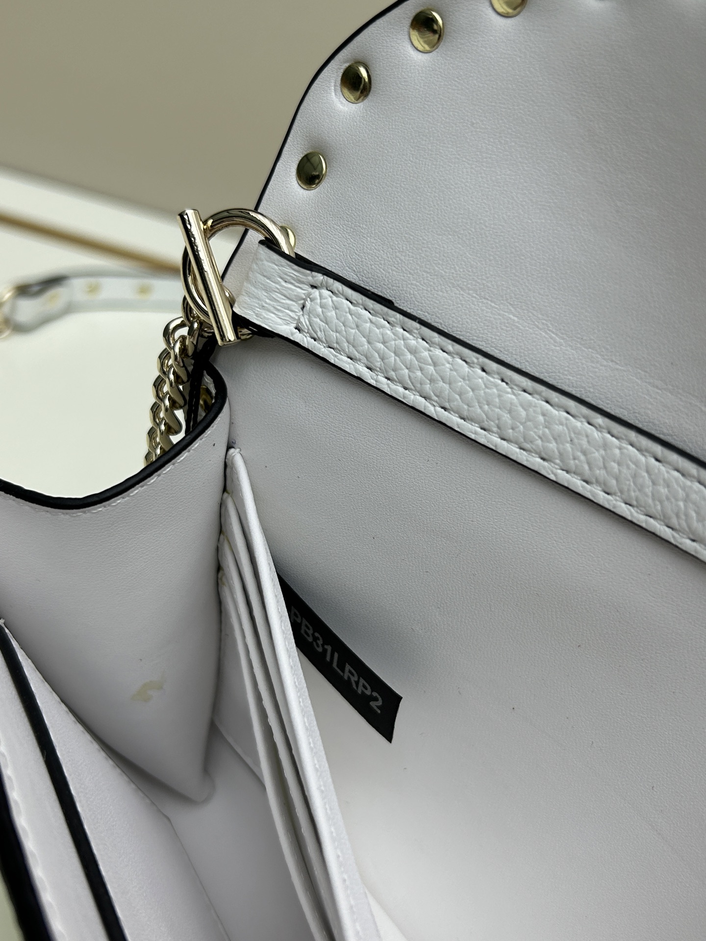 Garavani Rockstud 小号牛皮斜挎包，标志性的钩扣开合设计-金属工艺效果处理铆钉和配件-开