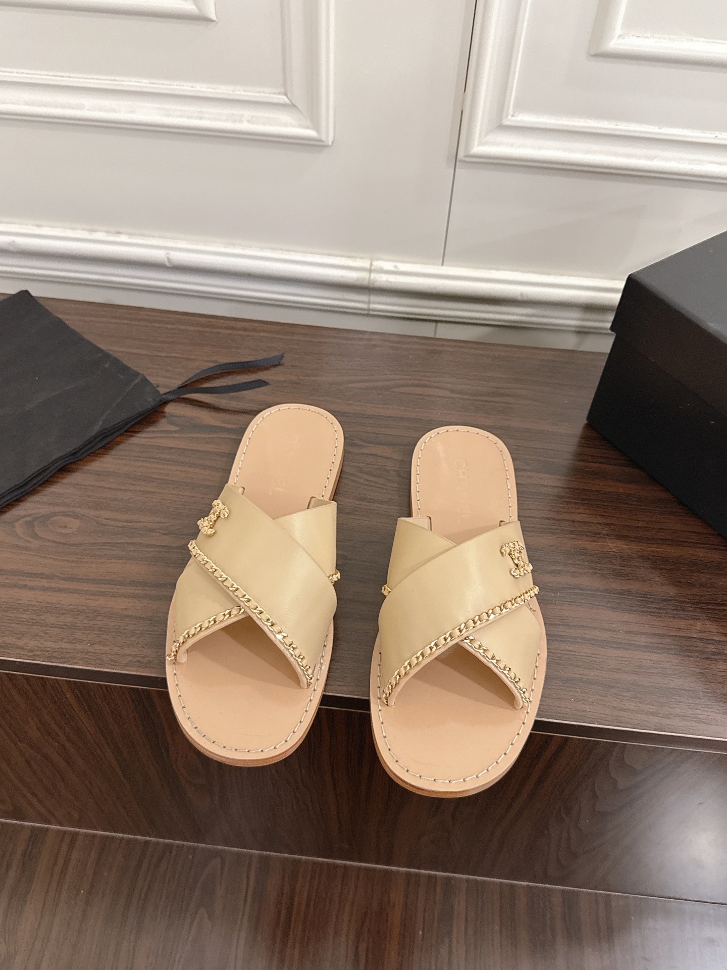 NO:645933,CHANEL Xiaoxiang's new chain flat sandals and slippers. This sandal opens the beginning of spring and summer with neat tailoring. The color matching design collides with fresh inspiration, and the hollow version allows the skin to embrace the breeze freely. Every step steps on a light rhythm. The wide anklet between the ankles is the finishing touch, and the huge pearl string trembles with the steps, continuing the original intention of Xiaoxiang pearls to become a feminine element. Breaking the boundary between luxury and daily life  Let sophistication not be exaggerated. The double C logo and the camellia ornaments complement each other. It is a direct expression of the brand spirit. The latter, as a symbol of purity and independence, hides the romantic traceability between the founder and his beloved. The flat design combines elegance and practicality to interpret Xiaoxiang's design philosophy of 'symbiosis of fashion and comfort'. The fabric is original custom-made sheepskin, the lining is genuine leather, and the sole is imported genuine leather outsole from Italy.  size35-41 (40/41 customized), slippers, chanel, sandals, slippers, sheepskin, Leather soles19860909CHANEL小香新款链条平底凉鞋拖鞋 这款凉鞋以利落剪裁开启春夏序章.拼色设计碰撞出鲜活灵感,中空版型让肌肤与微风自在相拥.每一步都踩着轻盈韵律 .脚踝间的宽幅脚环是点睛之笔,硕大珍珠串饰随步履轻颤,延续着小香珍珠成为柔美元素的初心.打破华贵与日常的边界 让精致无需浮夸.双C标识与山茶花饰件交相辉映.是品牌精神的直接表达,后者作为纯洁与独立的象征,藏着创始人与挚爱之间的浪漫溯源.平底设计兼顾优雅与实用诠释小香'时尚与舒适共生'的设计哲学. 面料原版定制羊皮 内里真皮 鞋底意大利进口真皮大底 size35-41（40/41定制）,拖鞋,chanel,sandals,slippers,sheepskin,Leather soles,Women's Shoes