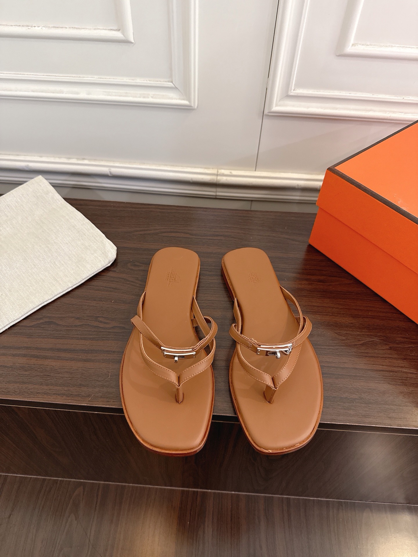 NO:751214,Hermès classic kelly buckle thin strap flip-flops, classic 'H' slippers, designed with the iconic 'H' shaped leather strap, simple and high-end. The upper is made of soft genuine leather with exquisite stitching, and the genuine leather sole is printed with the brand logo. It is matched with an orange packaging box and fabric bag. It is highly recognizable and combines comfort and fashion. The upper is made of original custom cowhide and the lining is sheepskin. The outsole is original Italian leather.  Size 35-41 (40 and 41 customized are not returnable), split-toe shoes, hermes, hermes, slippers, cowhide, sheepskin, Leather soles19860909Hermès 爱马仕经典kelly扣细带夹脚拖鞋 经典“H”字拖,采用标志性“H”形皮革带设计,简约高级.鞋面为柔软全真皮,配精致缝线,鞋底真皮底 印有品牌标识,搭配橙色包装盒与织物袋,辨识度高,兼具舒适与时尚. 鞋面原版定制牛皮 内里羊皮 大底原版意大利真皮大底 码数35-41（40、41定制不退换）,分趾鞋,hermes,hermes,slippers,cowhide,sheepskin,Leather soles,Women's Shoes