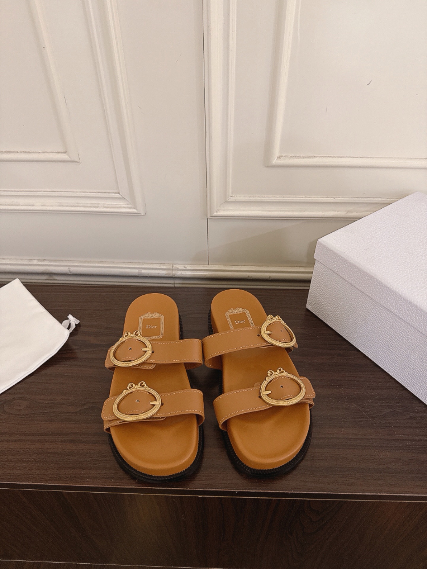 NO:883579,Dior 26ss spring and summer new double-strap metal buckle flat sandals. The double-strap design is equipped with retro round metal buckles. The lines are neat and simple, with a relaxed retro texture. It can easily adapt to a variety of styles and is a versatile style in the summer shoe cabinet. Pair it with denim shorts for casual casualness, with long skirts for a gentle and lazy style, and with wide-leg pants for a relaxed atmosphere. Whether it is for daily outings, vacations or at home, it can be easily controlled. Upper cowhide leather lining Sheepskin  Outsole original molded outsole size 35-41 (customized sizes 40 and 41 are not returnable) Heel height 3cm, slippers, dior, slippers, skirts, shorts, cowhide, sheepskin19860909Dior 26ss春夏新款双带金属扣平底凉拖 双带设计搭配复古圆形金属扣,线条利落简约,自带松弛的复古质感,轻松适配多种穿搭风格,是夏日鞋柜里的百搭款. 搭配牛仔短裤随性休闲,搭配长裙温柔慵懒,搭配阔腿裤又能穿出松弛氛围感,无论是日常出街、度假出行还是居家外穿,都能轻松驾驭. 鞋面牛皮 内里羊皮 大底原版开模大底 size35-41码（40、41码定制不退换） 跟高3cm,拖鞋,dior,slippers,skirts,shorts,cowhide,sheepskin,Women's Shoes