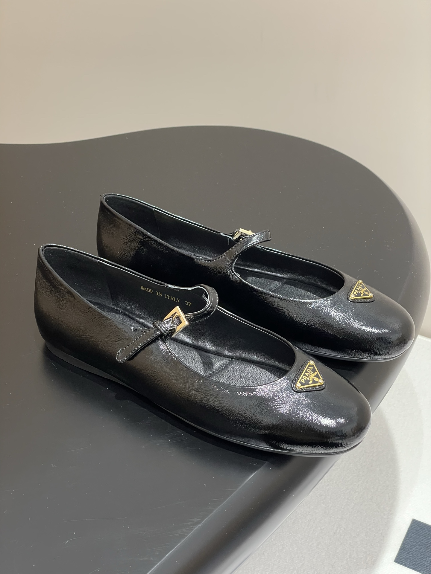 NO:669872,- Comes with airplane case 25Ss early spring new Prada wrinkled patent leather ballet flats Mary Jane ballet flats These ballet flats have a tapered silhouette, and the patent sheep leather adds a touch of sophistication, highlighting elegant and feminine charm. It has a round toe design, with a rubber sole, and is decorated with an enameled triangle metal logo, highlighting classic lines and exquisite elegant details. The upper is embellished with ribbons and engraved logo metal buckles. Enamel triangle metal logo  5 mm one-piece sole, decorated with heat-embossed logo Original wrinkled patent leather upper Sheepskin lining Heel high flat sole Original rubber sole Size 35-39 (40, 41 customization is non-refundable), ballet shoes, prada, prada, mary jane, flats, sheepskin19860909-配飞机盒 25Ss早春新款Prada普拉达皱漆皮芭蕾平底鞋玛丽珍芭蕾舞平底单鞋 这款芭蕾平底鞋采用锥形廓形,漆面羊皮革平添一抹精致,彰显优雅柔美魅力.采用圆头设计,搭配橡胶鞋底,且饰有涂珐琅三角形金属徽标,彰显经典线条和精致优雅细节. 鞋面点缀饰带与雕刻徽标金属搭扣 涂珐琅三角形金属徽标 5毫米一体式鞋底,饰有热压徽标 鞋面原版皱漆皮 内里羊皮内里 跟高平底 鞋底原版橡胶鞋底 码数35-39（40,41定制不退换）,芭蕾舞鞋,prada,prada,mary jane,flats,sheepskin,Women's Shoes