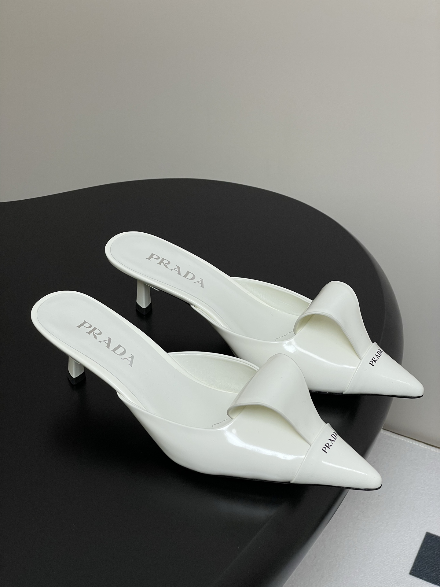 NO:679693,-With airplane case, 25ss early spring new Prada catwalk model, pointed toe kitten heel slippers, toe-toe Mule half-slippers, Prada Mule shoes are simply amazing!  Placed on the shoe box, this appearance is stunning at a glance. The off-white color is gentle and fresh, as if it can inject an elegant temperament into the outfit. The black style is cool and capable, with a full sense of high-end. The pointed toe design subtly elongates the leg line, making the feet delicate and charming. The simple Prada logo on the upper is low-key and highlights the brand style. Moreover, these mule shoes are super easy to put on and take off, who knows how happy they are to slip on!  Whether paired with a simple dress or casual wide-leg pants, they can be easily matched and add a lot of points to the overall look. I feel like I have these two pairs of shoes, and I don’t have to worry about matching them when I go out every day. The upper is open-edge beaded cowhide, the lining is sheepskin/open-edge bead padding, the sole is Italian dyed genuine leather, and the heel height is 5cm.  heels,slippers,skirts,cowhide,sheepskin,Leather soles19860909-配飞机盒 25ss早春新款Prada普拉达走秀款 尖头小猫跟拖鞋 包头穆勒半拖鞋 Prada穆勒鞋简直太可了！摆在鞋盒上,这颜值一眼沦陷.米白色温柔又清新,仿佛能为穿搭注入一股优雅气质 .而黑色的款式,则透着酷帅干练,满满的高级感. 尖头设计,巧妙地拉长腿部线条,显得双脚精致又迷人.鞋面上简洁的Prada标识,低调又彰显品牌格调.而且这种穆勒鞋穿脱超方便,一脚蹬的快乐谁懂！ 不管是搭配简约的连衣裙,还是休闲的阔腿裤,它们都能轻松适配,为整体造型加分不少.感觉拥有了这两双鞋,每天出门都不愁没搭配啦 鞋面开边珠牛皮 内里垫脚羊皮/开边珠垫脚 鞋底意大利染色真皮大底 跟高5cm 码数35-39（40.41定做不退换）,半拖高跟鞋,prada,prada,high heels,slippers,skirts,cowhide,sheepskin,Leather soles,Women's Shoes