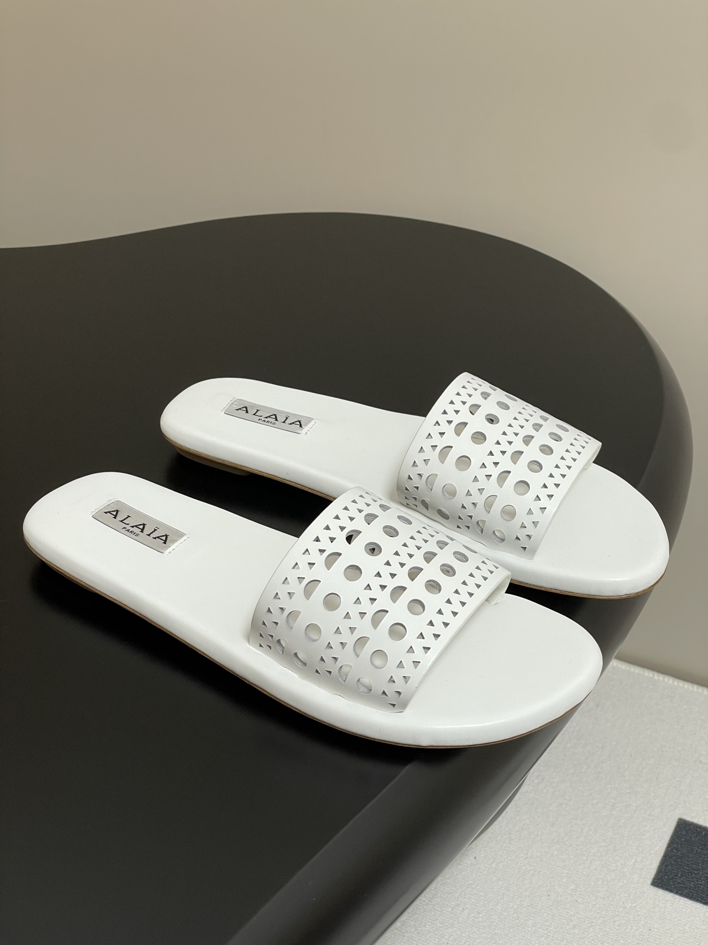 NO:232718,- 25ss Spring and Summer New ALAIA Vienne Hollow Carved Flat Sandals This flat mules are decorated with Vienne Hollow Carved Pattern inspired by precious lace and pane grille (Moucharabieh) architecture. The cowhide upper and sheepskin lining are elegant while being more comfortable and versatile. Full of girlish style, modern and retro flavor, very simple and atmospheric. Whether it is a skirt, dress or jeans, it can be the finishing touch!  Elegant and high-end!  Customized calfskin/sheep leather/punch carving technology Inner footbed sheepskin Sole Italian leather outsole Heel high flat sole Size: 35-41 (40.41 Custom made without return or exchange), Slippers, alaia, slippers, skirts, jeans, cowhide, sheepskin, sheep, Leather soles19860909- 25ss春夏新款ALAIA阿莱亚Vienne镂空雕花平底凉拖鞋 这款平底穆勒鞋饰以自珍贵蕾丝和遮窗格栅 (Moucharabieh)建筑汲取灵感的Vienne镂空雕花图案,牛皮革鞋面结合羊皮革衬里,兼具高雅的同时更加舒适百搭. 满满的少女风 既摩登又复古的味道 非常的简约大气 不管是半身裙,连衣裙还是牛仔裤 它都能成为点睛之笔！优雅高级！ 鞋面定制小牛皮/羊猄皮/冲孔雕花工艺 内里垫脚羊皮 鞋底意大利真皮大底 跟高平底 码数:35-41（40.41定做不退换）,拖鞋,alaia,slippers,skirts,jeans,cowhide,sheepskin,sheep,Leather soles,Women's Shoes