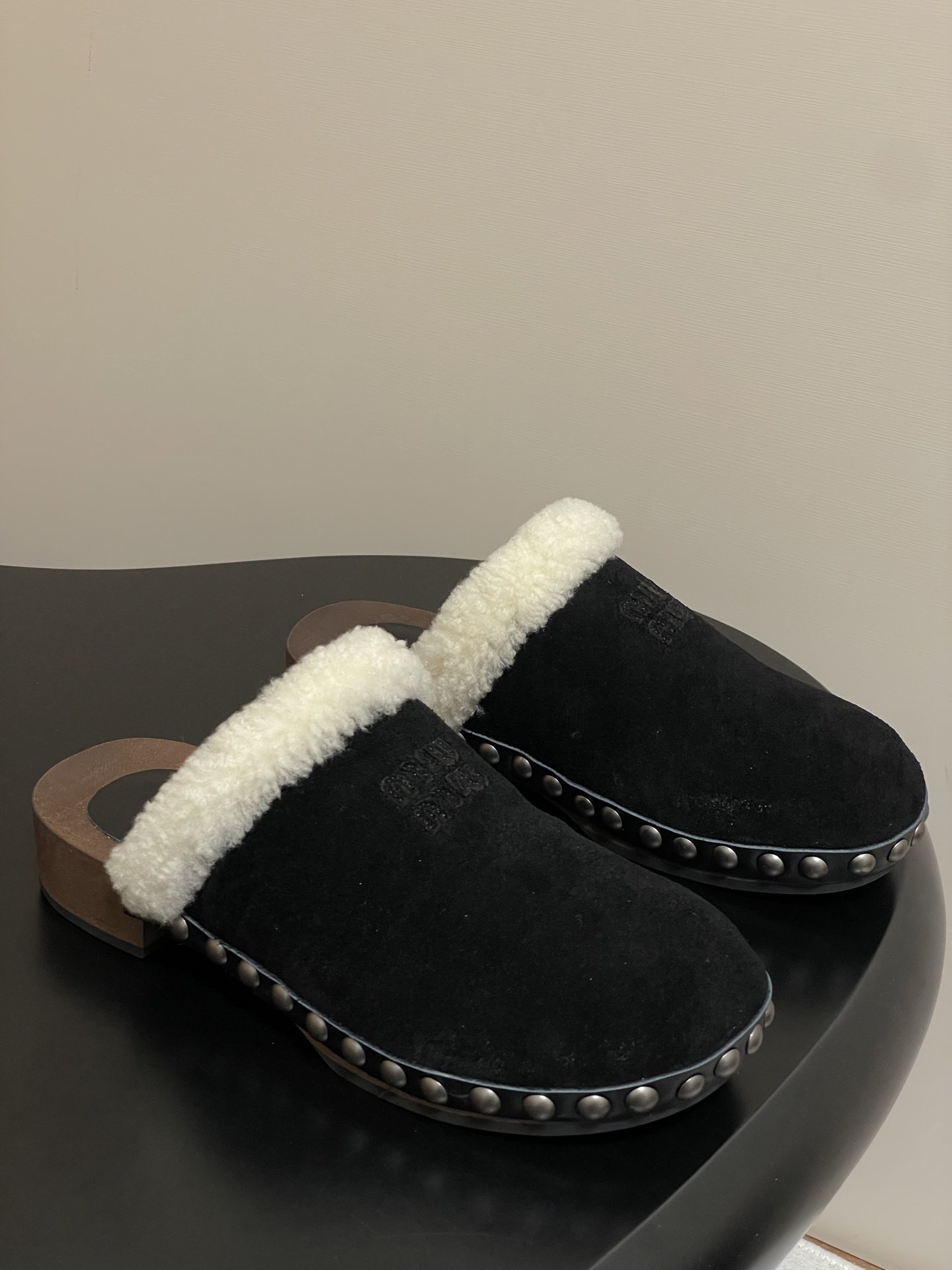 NO:441550,- 25ss autumn and winter catwalk MIUMIU Solid wood sole wool semi-slipper thick-soled mules The upper is made of suede material. This material not only has a soft touch, but also has a natural texture and retro charm, but also adds a sense of luxury to the shoes. There is a circle of plush decoration at the mouth of the shoe, which looks warm and comfortable, which not only enhances the fashion sense of the shoes, but also provides warm care for the ankles when worn, especially suitable for wearing in cooler seasons. There is a row of metal rivets on the side of the shoe. The addition of rivet elements adds a punk and fashionable feeling to the pair of slippers, breaking the monotony of traditional slippers, making the shoes more personalized and trendy. The upper is high mercerized beef leather, inner foot pad sheep curls, original open molded solid wood combination rubber sole  Number of codes 35-39 (40.41 custom made without return or exchange), fur shoes, miumiu, slippers, chamois leather19860909- 25ss秋冬走秀款MIUMIU 缪缪 实木底羊毛半拖鞋厚底穆勒鞋 鞋面采用了麂皮材质,这种材质不仅触感柔软,而且带有一种自然的质感和复古韵味,同时也能为鞋子增添一份高级感. 鞋口处有一圈毛绒装饰,看起来温暖又舒适,既提升了鞋子的时尚感,又能在穿着时为脚踝提供温暖的呵护,尤其适合在较凉爽的季节穿着. 鞋侧面有一排金属铆钉装饰,铆钉元素的加入为这双拖鞋增添了一份朋克风与时尚感,打破了传统拖鞋的单调感,让鞋子更具个性和潮流感. 鞋面高丝光牛猄皮 内里垫脚羊卷毛 鞋底原版开模实木组合橡胶大底 码数35-39（40.41定做不退换）,毛毛鞋,miumiu,slippers,chamois leather,Women's Shoes