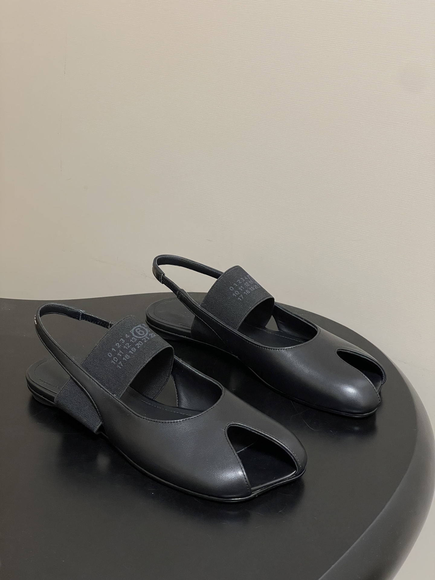 NO:630198,- MaisonMargiela｜26 spring and summer new model MM6 Margiela, iconic letter elastic band Mary Jane shoes, personalized open-toe flat sandals, MM6 'black rubber pointed last open-toe slippers' | Turn laziness into high-end sharpness, pinch the softness of ballet shoes into sharp outlines, open-toe cutout is the 'caution' in laziness. 'Matte black leather wrapped in deconstructed lines  Stepping on it is the Parisian fashion of 'effortless but winning'. Sheepskin upper, sheepskin lining, Italian genuine leather outsole, size 35-39 (custom-made for 40, non-refundable), sandals, masion margiela, masion margiela, sandals, mary jane, sheepskin, Leather soles19860909- MaisonMargiela｜26春夏新款MM6马吉拉 标志性字母弹力带玛丽珍鞋个性露趾后空平底凉鞋 MM6「黑胶尖楦露趾拖」 ｜把慵懒踩成高级锐度 把芭蕾鞋的柔捏成尖锐轮廓 露趾切口是慵懒里的“小心机” ”哑光黑皮革裹着解构线条 踩上就是巴黎人那种“没费力但赢很大”的时髦  鞋面羊皮 内里垫脚羊皮 鞋底意大利真皮大底 码数35-39（40定做不退换）,凉鞋,masion margiela,masion margiela,sandals,mary jane,sheepskin,Leather soles,Women's Shoes