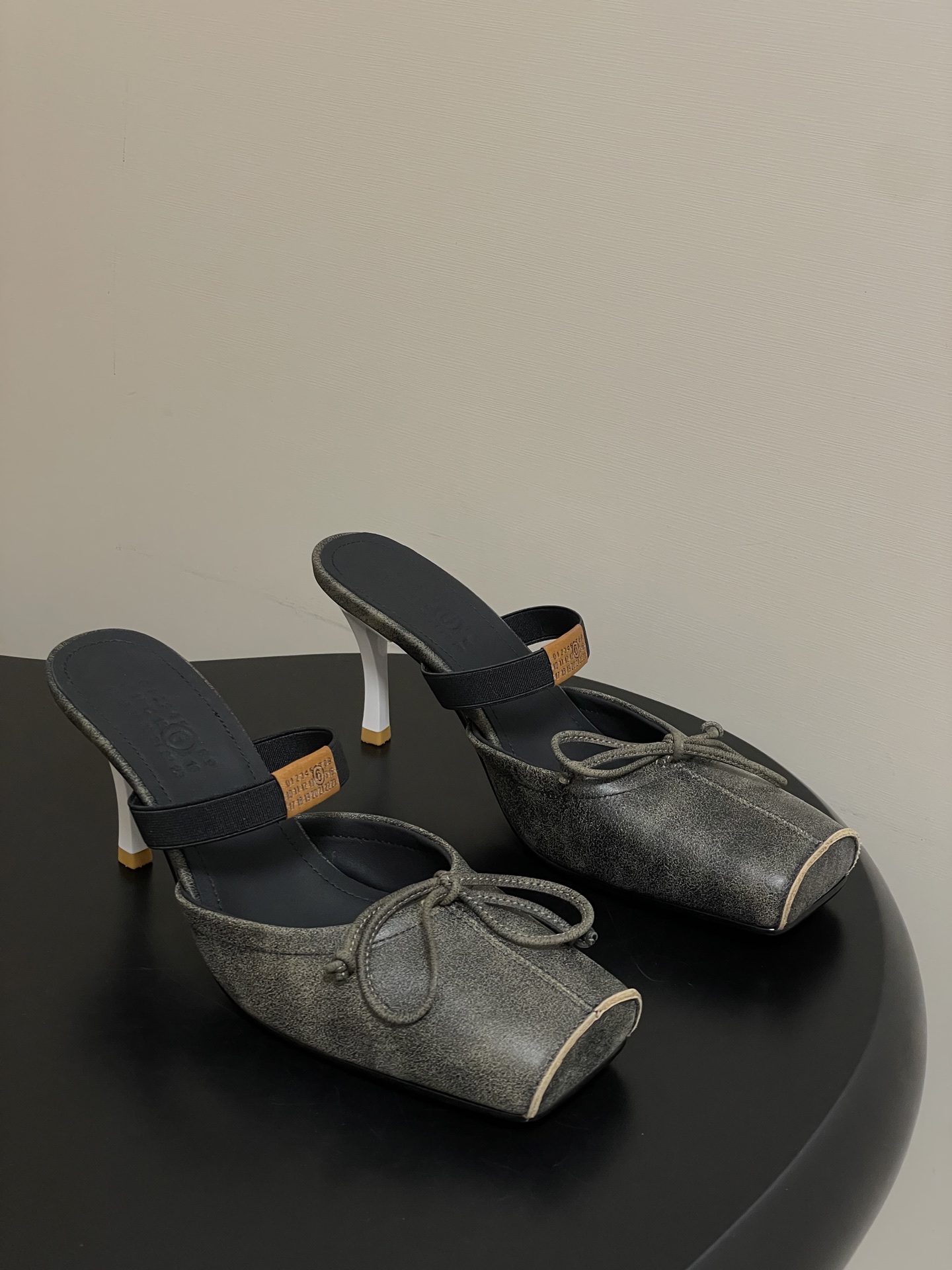 NO:650368,- MaisonMargiela｜26 spring and summer new model MM6 Margiela Iconic letter elastic band toe-cap high-heeled sandals square-toe retro-style personalized flat-head bow high-heeled sandals The softness of ballet shoes is pinched into a sharp outline. The open-toe cutout is a 'careful trick' in laziness. 'Matte black leather is wrapped in deconstructed lines. Stepping on it is the Parisian fashion of 'effortless but winning'. Upper cowhide, lining foot cowhide  Sole Italian genuine leather outsole, heel height 8cm, size 35-39 (40 customized, non-refundable), high heels ballet shoes, masion margiela, masion margiela, high heels, slippers, cowhide, Leather soles19860909- MaisonMargiela｜26春夏新款MM6马吉拉 标志性字母弹力带包头高跟凉拖鞋方头复古风个性平头蝴蝶结高跟凉拖鞋 把芭蕾鞋的柔捏成尖锐轮廓 露趾切口是慵懒里的“小心机” ”哑光黑皮革裹着解构线条 踩上就是巴黎人那种“没费力但赢很大”的时髦  鞋面牛皮 内里垫脚牛皮 鞋底意大利真皮大底 跟高8cm 码数35-39（40定做不退换）,高跟鞋芭蕾舞鞋,masion margiela,masion margiela,high heels,slippers,cowhide,Leather soles,Women's Shoes