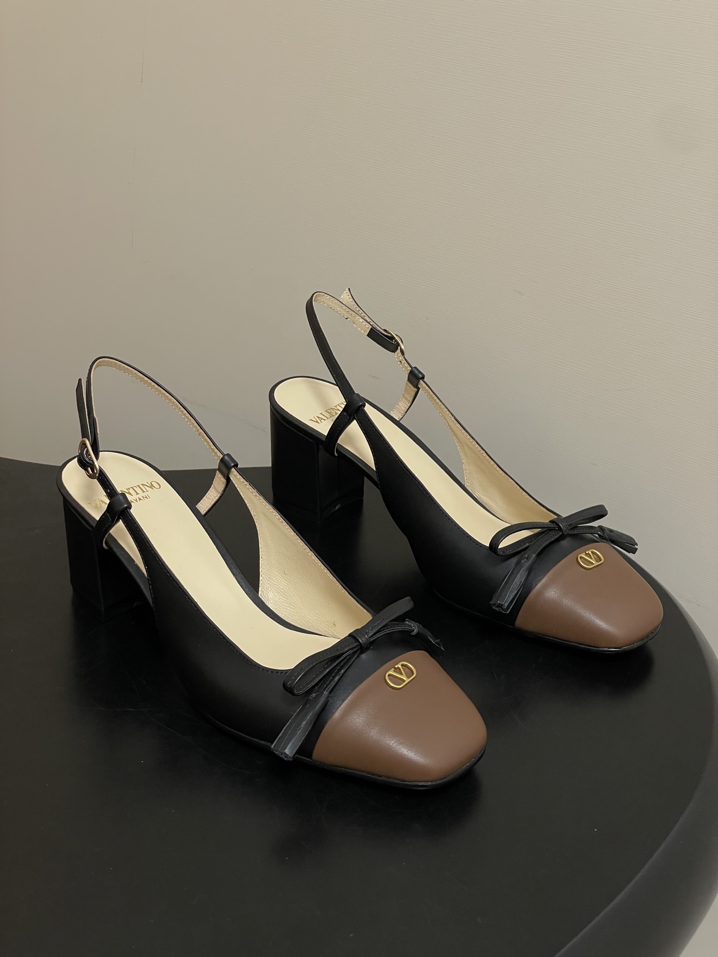 NO:707648,-Top quality (with high-end airplane box 10) Valentino VALET DU ROI series double color Mary Jane shoes bow thick heel back empty sandals classic hardware V buckle high-heeled shoes  A large bow is decorated on the toe, which is a highlight of the design of this pair of shoes. The bow is also made of off-white leather of the same color as the upper. The shape is full and three-dimensional, adding to the sweetness and feminine characteristics of the shoes, making the original simple shoes more flexible, and also improving the overall fashion and sophistication. This pair of shoes has a playful and cute style while being elegant, which is in line with the aesthetic needs of many women today for shoes that have both temperament and personality.  The mid-heel design and moderate heel height can not only increase the wearer's height and temperament, but also show an elegant posture without putting too much pressure on the feet like high-heeled shoes. They are relatively comfortable and suitable for daily wear or some formal occasions that do not require standing and walking for a long time, such as workplaces and more relaxed social gatherings. Customized calfskin upper, water-dyed sheepskin lining, Italian A-grade leather outsole, heel height 6cm  Size 35-39 (34.40.41 customized, non-refundable), sandals, valentino, valentino, sandals, mary jane, high heels, cowhide, sheepskin, Leather soles19860909-顶级品质（配高档飞机盒10） Valentino 华伦天奴 VALET DU ROI系列双拼色玛丽珍鞋蝴蝶结粗跟后空凉鞋经典五金V扣高跟单鞋 鞋头一个大大的蝴蝶结装饰,这是这双鞋的一大亮点设计.蝴蝶结同样采用与鞋面同色系的米白色皮革制作,造型饱满立体,增添了鞋子的甜美感和女性化特质,让原本简约的鞋款变得灵动起来,同时也提升了整体的时尚度和精致感,使这双鞋在优雅中又带有一丝俏皮可爱的风格,很符合当下很多女性对于鞋履既要有气质又要有个性的审美需求. 中跟设计,鞋跟高度适中,既能够增加穿着者的身高和气质,展现出优雅的身姿,又不会像高跟鞋那样给脚部带来过多的压力,相对比较舒适,适合日常穿着或者一些正式但不需要长时间站立行走的场合,比如职场办公、参加较为轻松的社交聚会等. 鞋面定制小牛皮 内里垫脚水染羊皮 鞋底意大利A级真皮大底 跟高6cm 码数35-39（34.40.41定做不退换）,凉鞋单鞋,valentino,valentino,sandals,mary jane,high heels,cowhide,sheepskin,Leather soles,Women's Shoes