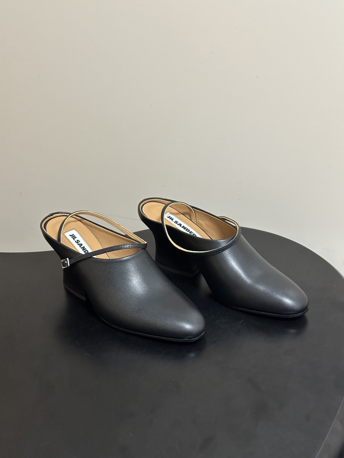 NO:815000,JIL SANDER 26Fw new spring and summer retro-style thick heel thin strap buckle mules/deep-mouth single shoes and high-heeled shoes Minimalist deep-mouth single shoes | cool and artistic walking footnotes Incorporate the alienation of literature and art and the soft daily life into the shoe shape. Every step has a faint sense of narrative. The clean single-strap design is like a line rubbed by the wind. It comes with a cool soft light filter. The open-toe cut is gentle and light, without deliberate modification.  Only the texture of the leather itself and the silhouette of the shoe hide an unconventional spontaneity. It goes well with linen skirts, loose knits, and plain shirts. It has an unintentional literary and artistic atmosphere. It is suitable for those who prefer 'cool and gentle' outfits. It is low-key but tasteful enough. Cowhide upper, sheepskin lining, Italian genuine leather outsole, heel height 5.5cm  Size 35-39 (34.40.41 customized, non-returnable), sandals, jil sander, jil sander, sandals, high heels, skirts, shirts, cowhide, sheepskin, Leather soles19860909JIL SANDER 吉尔桑达 26Fw春夏新款复古风粗跟细带搭扣穆勒鞋/深口单鞋高跟鞋 极简深口单鞋｜清冷文艺的行走注脚 把文艺的疏离与柔软的日常揉进鞋型里 每一步都带着淡淡的叙事感 干净利落的单带设计 像被风揉过的线条 自带清冷的柔光滤镜 露趾剪裁温柔又轻盈 没有刻意的修饰 只有皮革本身的质感与鞋型的轮廓 藏着不迎合的随性 搭配亚麻长裙、宽松针织、素色衬衫都适配 是不刻意的文艺氛围 适合偏爱「清冷又温柔」的穿搭 低调却足够有味道 鞋面牛皮 内里垫脚羊皮 鞋底意大利真皮大底 跟高5.5cm 码数35-39（34.40.41定做不退换）,凉鞋单鞋,jil sander,jil sander,sandals,high heels,skirts,shirts,cowhide,sheepskin,Leather soles,Women's Shoes